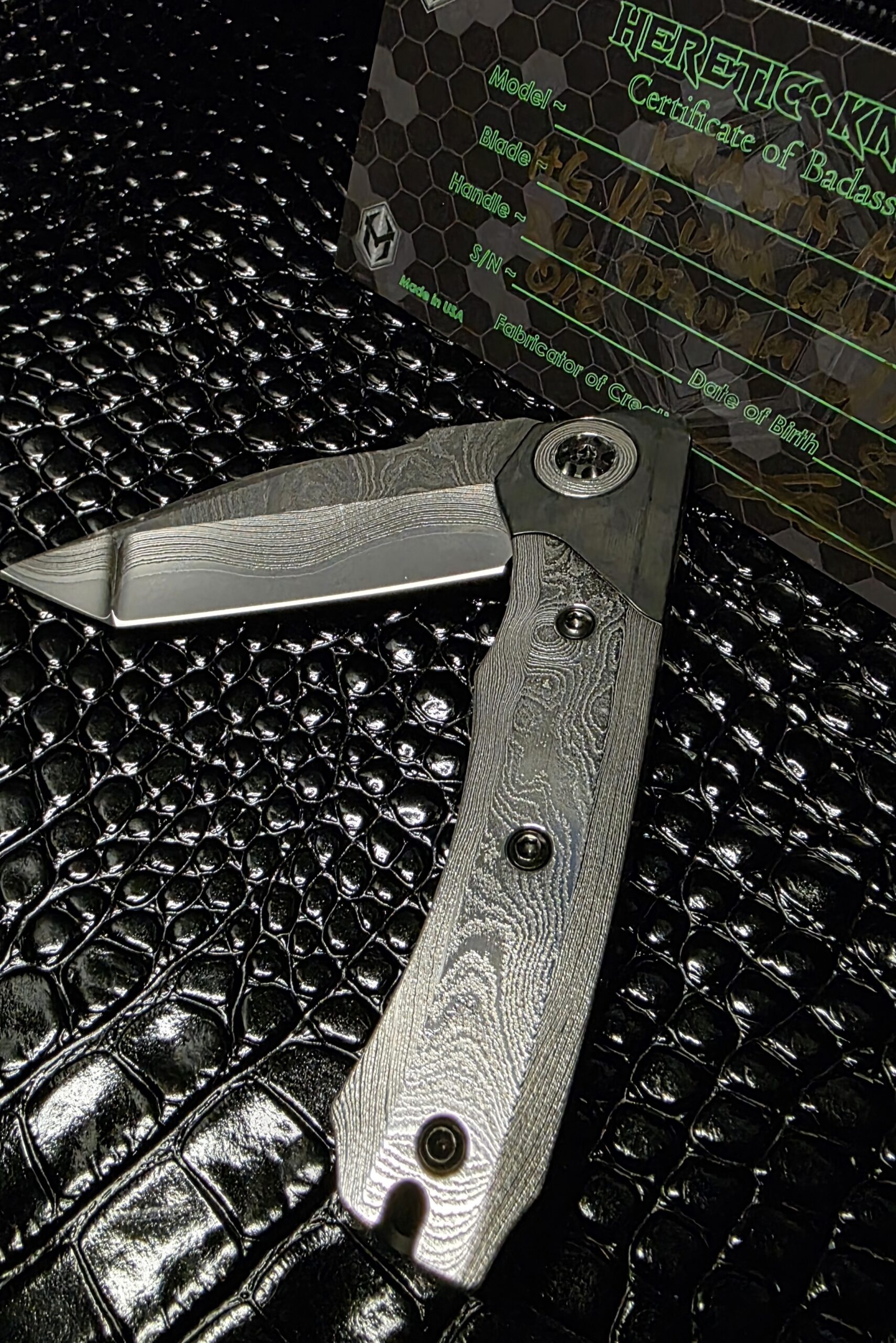 Heretic Knives Custom Wraith folding knife with wood grain textured titanium handle