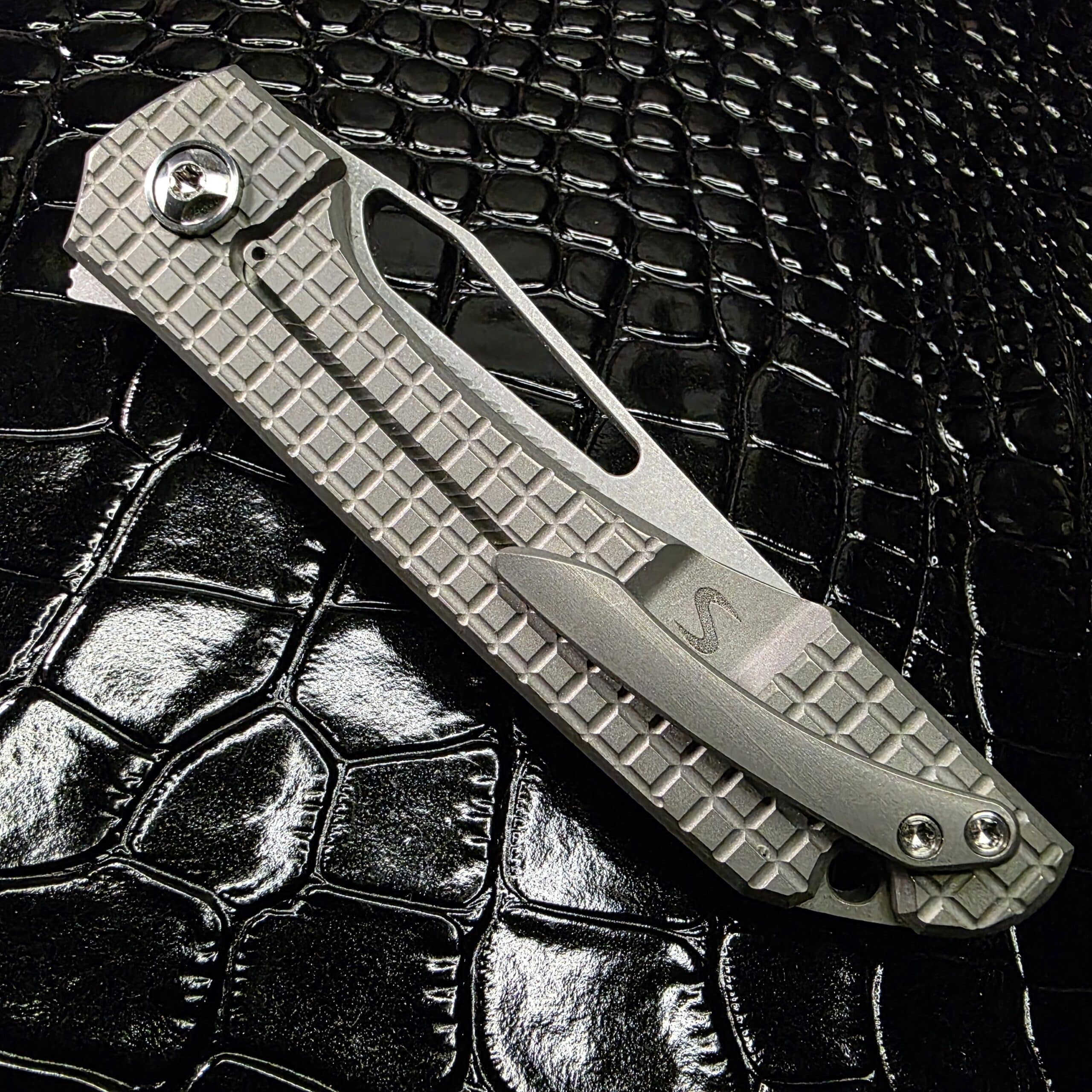 Lock side view of Simeon Custom Knives UnTo showing tumbled frag titanium handle and raw titanium hardware
