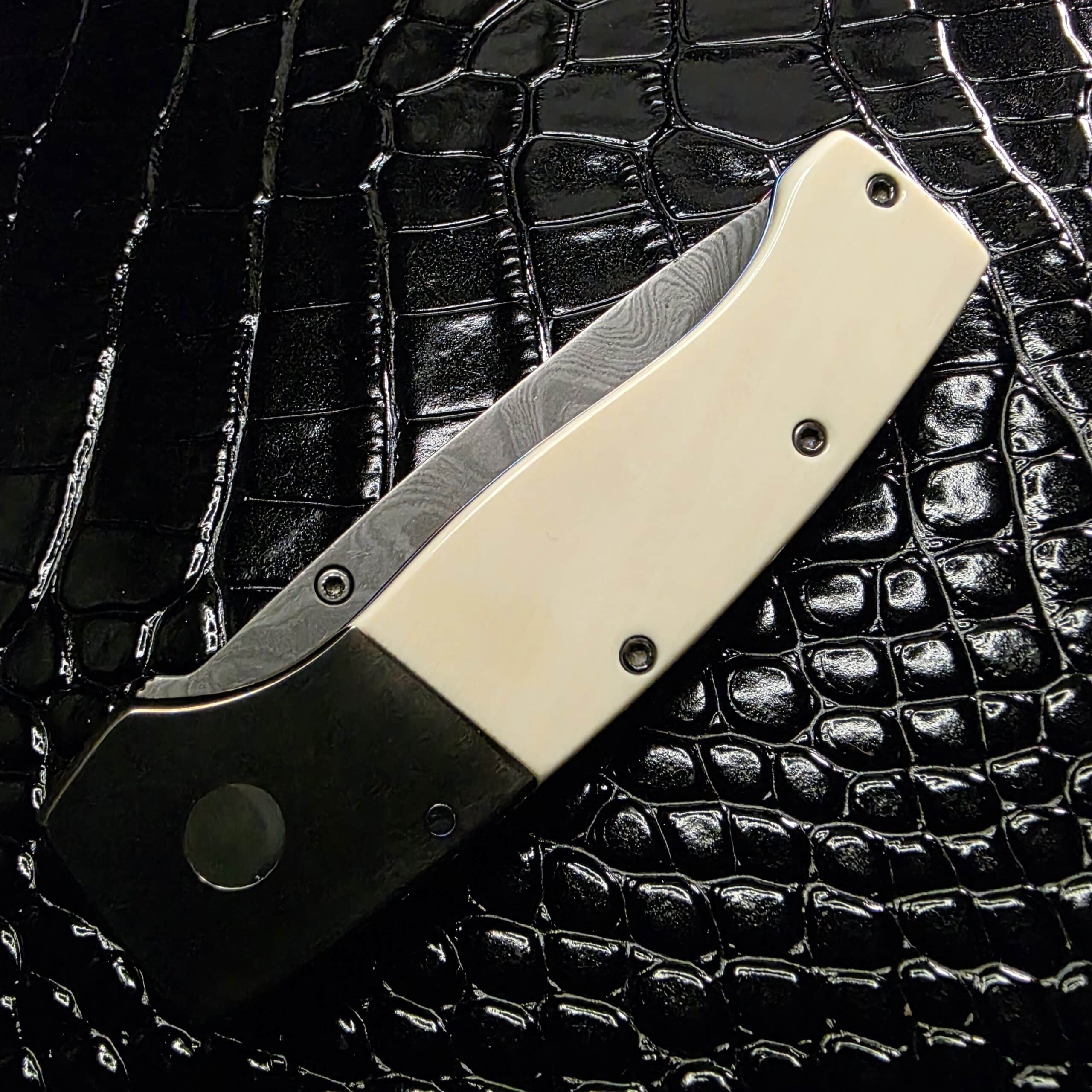 Dovetailed ivory scales fitment on Kit Carson custom knife handle with clean seams and polish