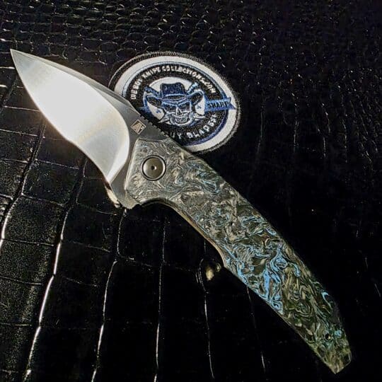 A2 Knives A6R Flipper open view showing M390 blade and Blue Dark Matter FatCarbon scales