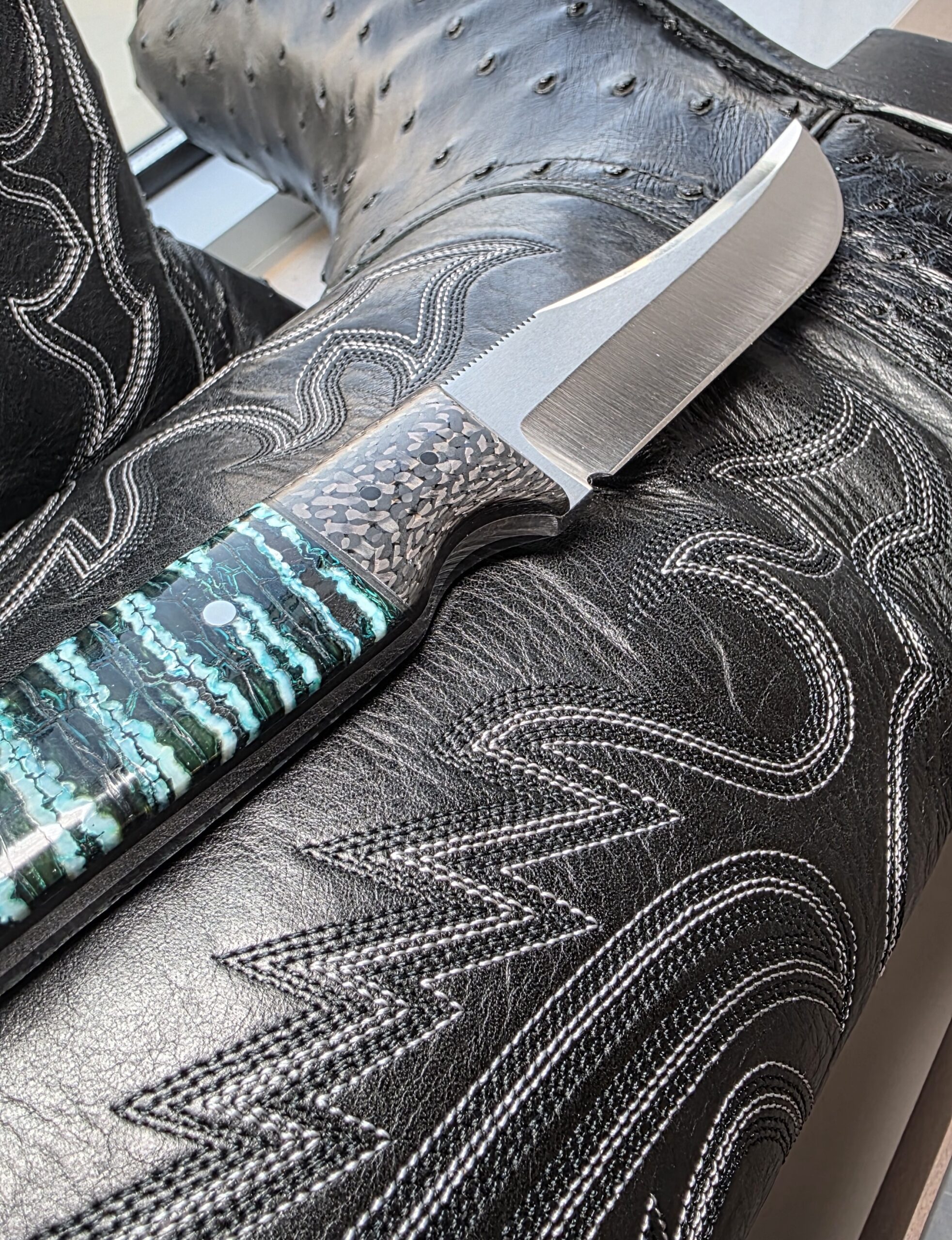 Vibrant green mineral deposits in the stabilized mammoth tooth handle of a Holley custom hunter.