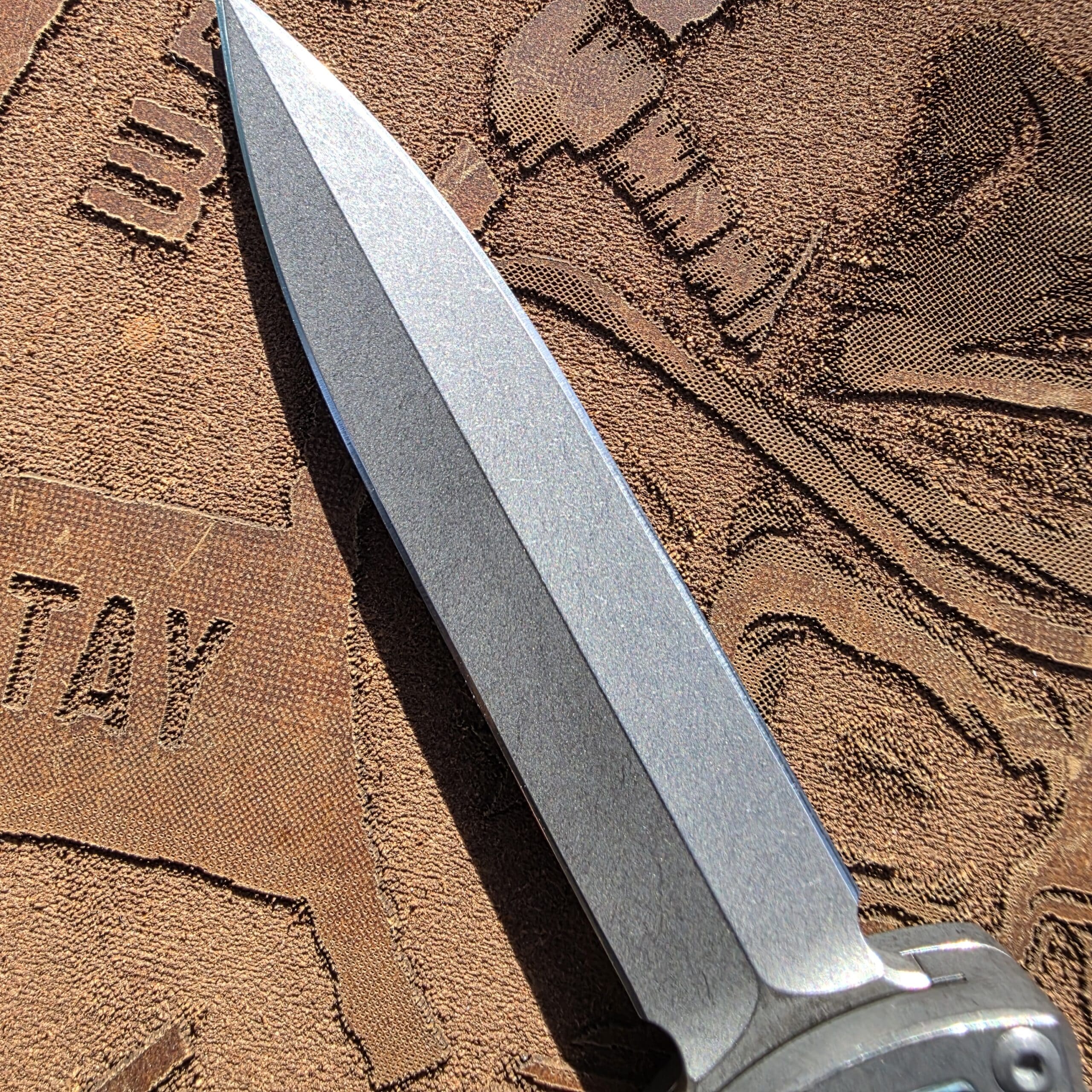 Macro view of the M390 dagger tip on a Hawk Deadlock Model C.