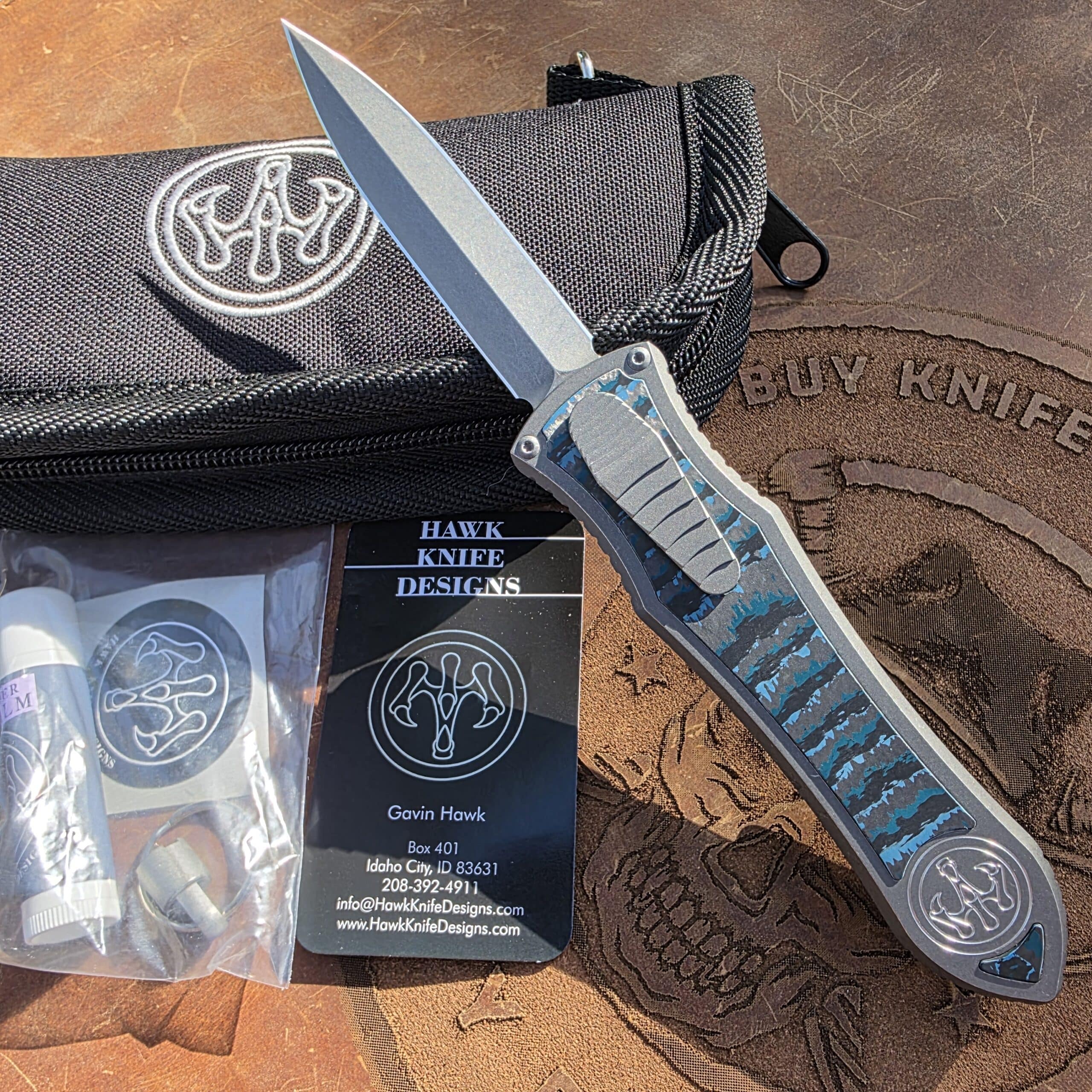 Presentation side of the Hawk Deadlock Model C showing blue carbon fiber and zero-play construction.