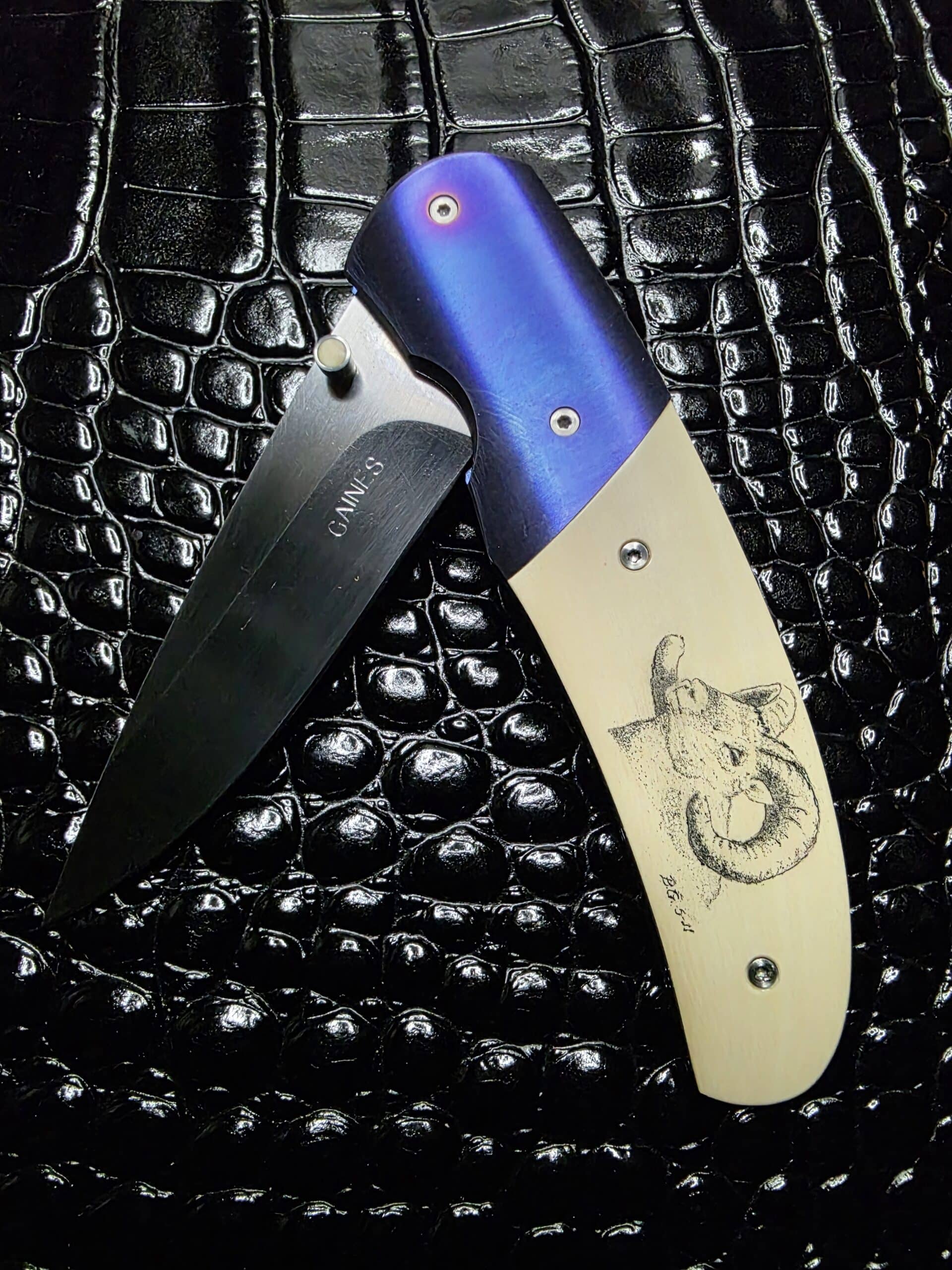 Buddy Gaines Custom Knife featuring scrimshawed mammoth ivory and blue titanium bolsters.