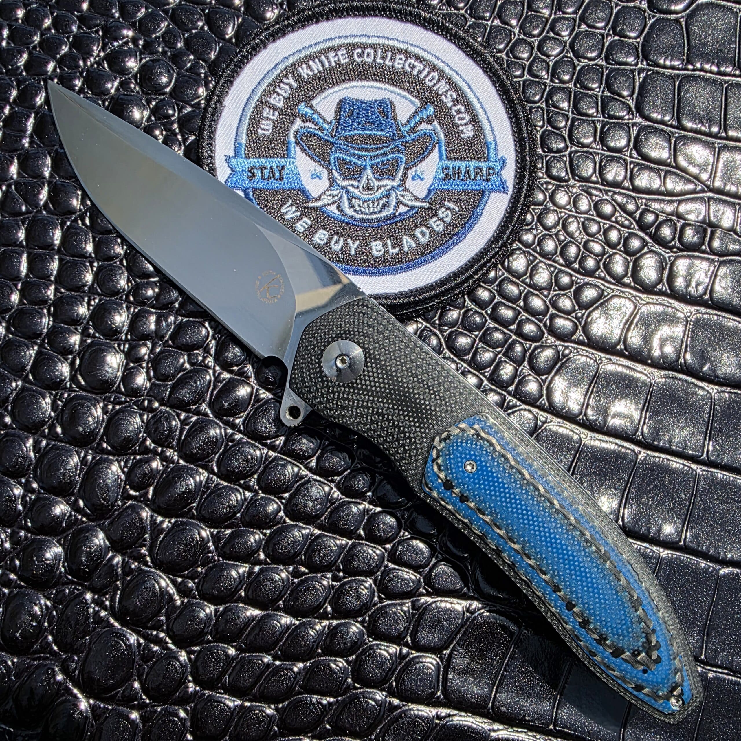 The Keith Kruger Custom K4 Interframe Flipper with blue and black carbon fiber inlays shown in a full show-side profile.