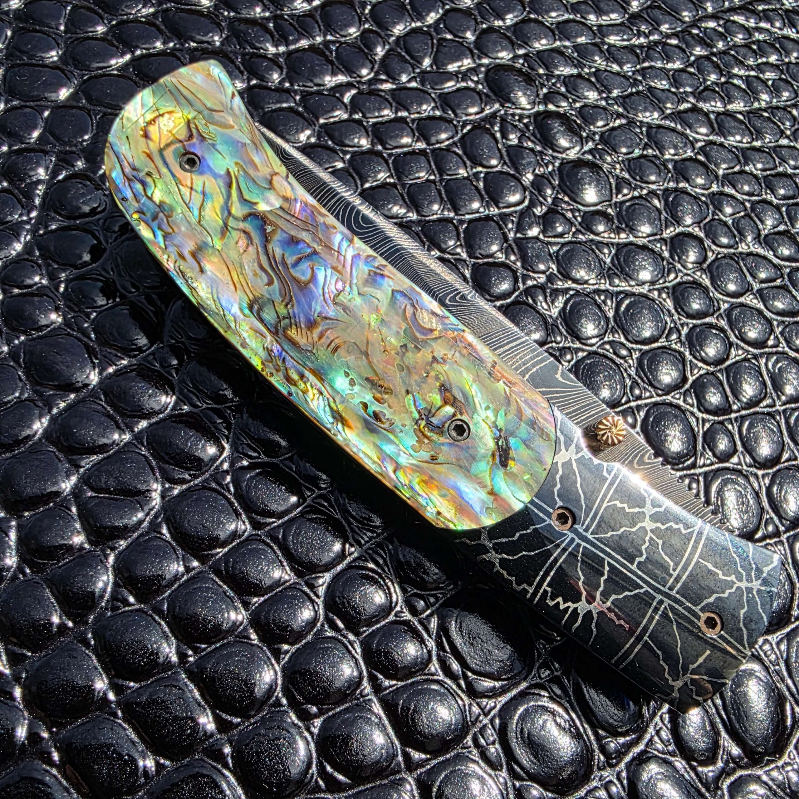 Secondary hero image of Jeff Chaffee custom linerlock showing abalone shell and Damascus details