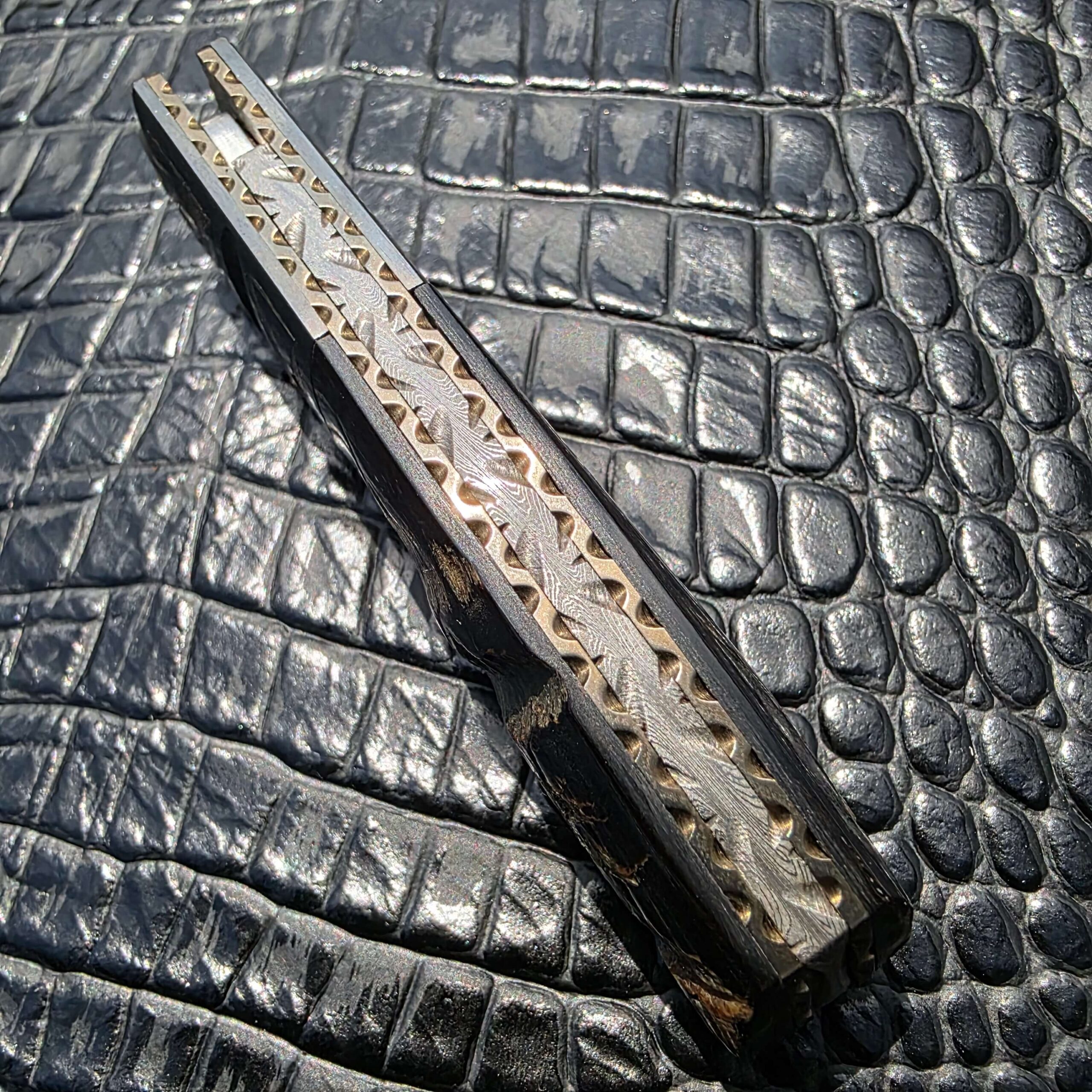 Engraved steel bolster detail on Mel Pardue custom engraved tanto linerlock