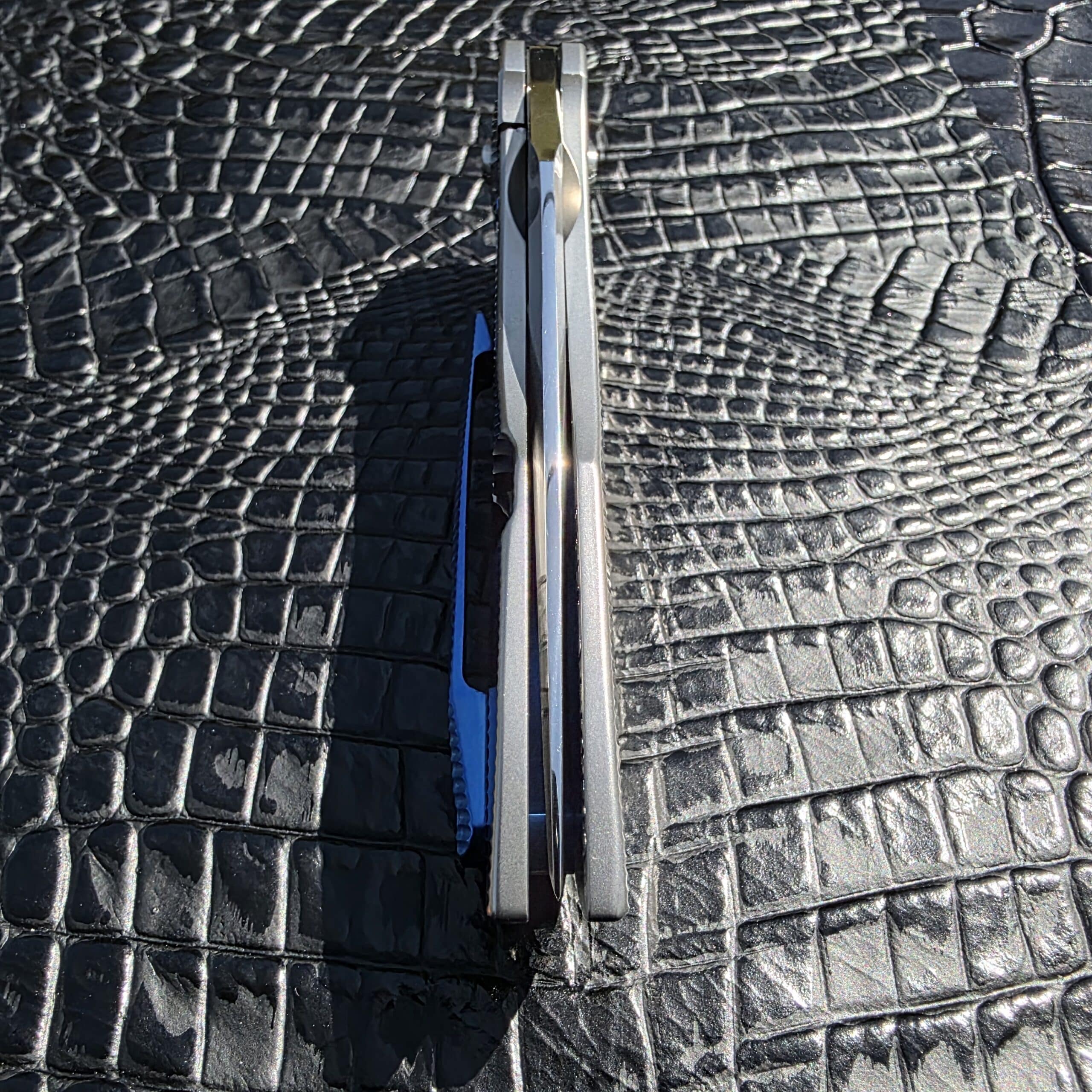 File Name: skiff-made-blades-culprit-backspacer-detail.jpg Alt Text: Blue anodized titanium backspacer on Skiff Made Blades Culprit Image Title: Skiff Culprit Backspacer Detail Caption: Blue anodized titanium backspacer on the Culprit. Description: Detail image showing the backspacer and how it complements the blasted titanium handle. 14. Pocket Clip Detail File Name: skiff-made-blades-culprit-pocket-clip-detail.jpg Alt Text: Blue anodized titanium tip-up clip on Skiff Made Blades Culprit Image Title: Skiff Culprit Pocket Clip Detail Caption: Blue anodized titanium tip-up clip on the Skiff Made Blades Culprit. Description: Close-up image focused on the tip-up pocket clip and its contrasting anodized finish.