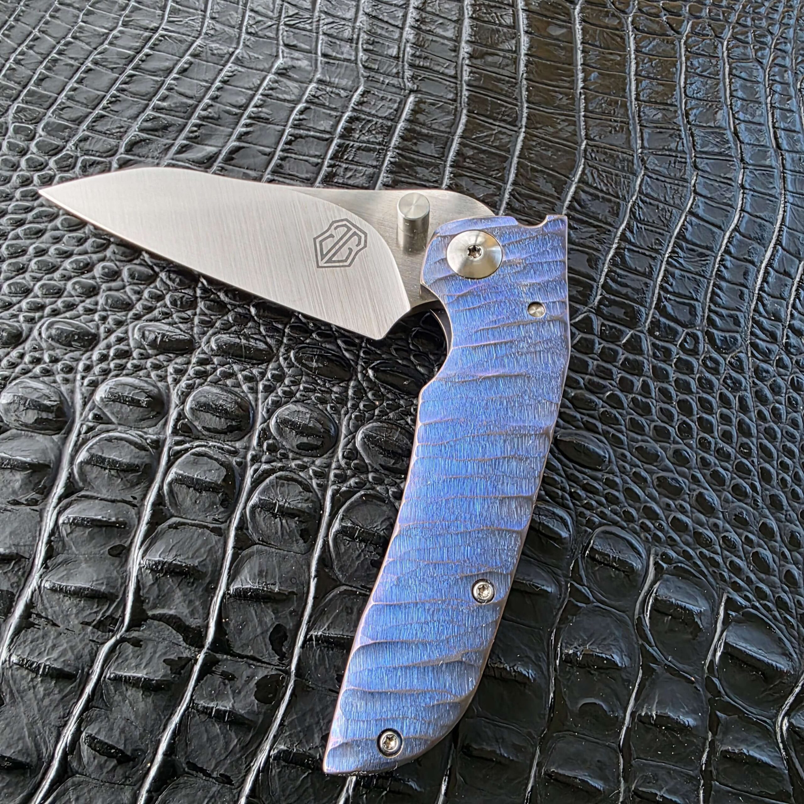 John Gray Custom Thuck open show-side with blue titanium rock grind handle