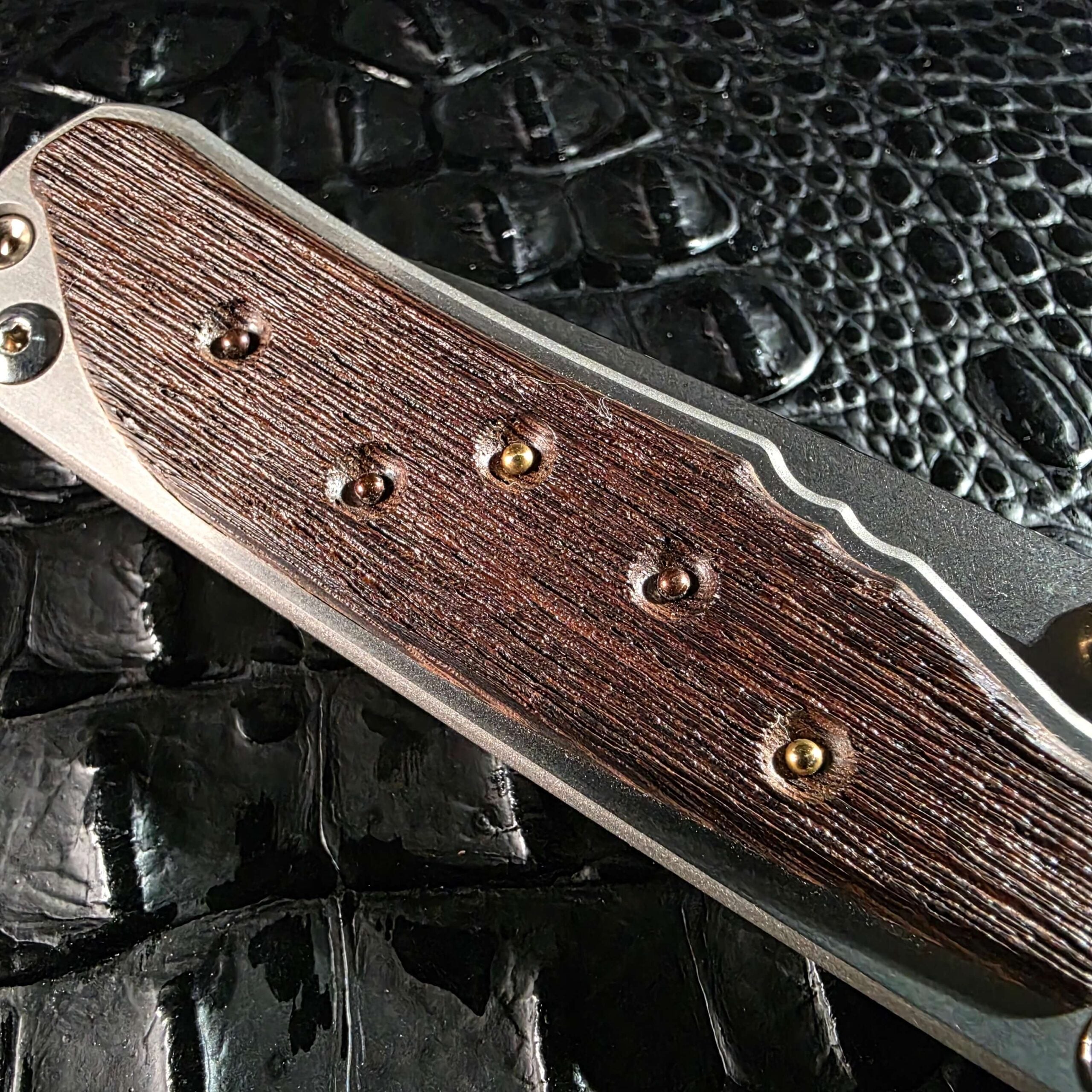 Macro of 18k gold and Argentium silver inlays set into wire-brushed Workbench Wenge
