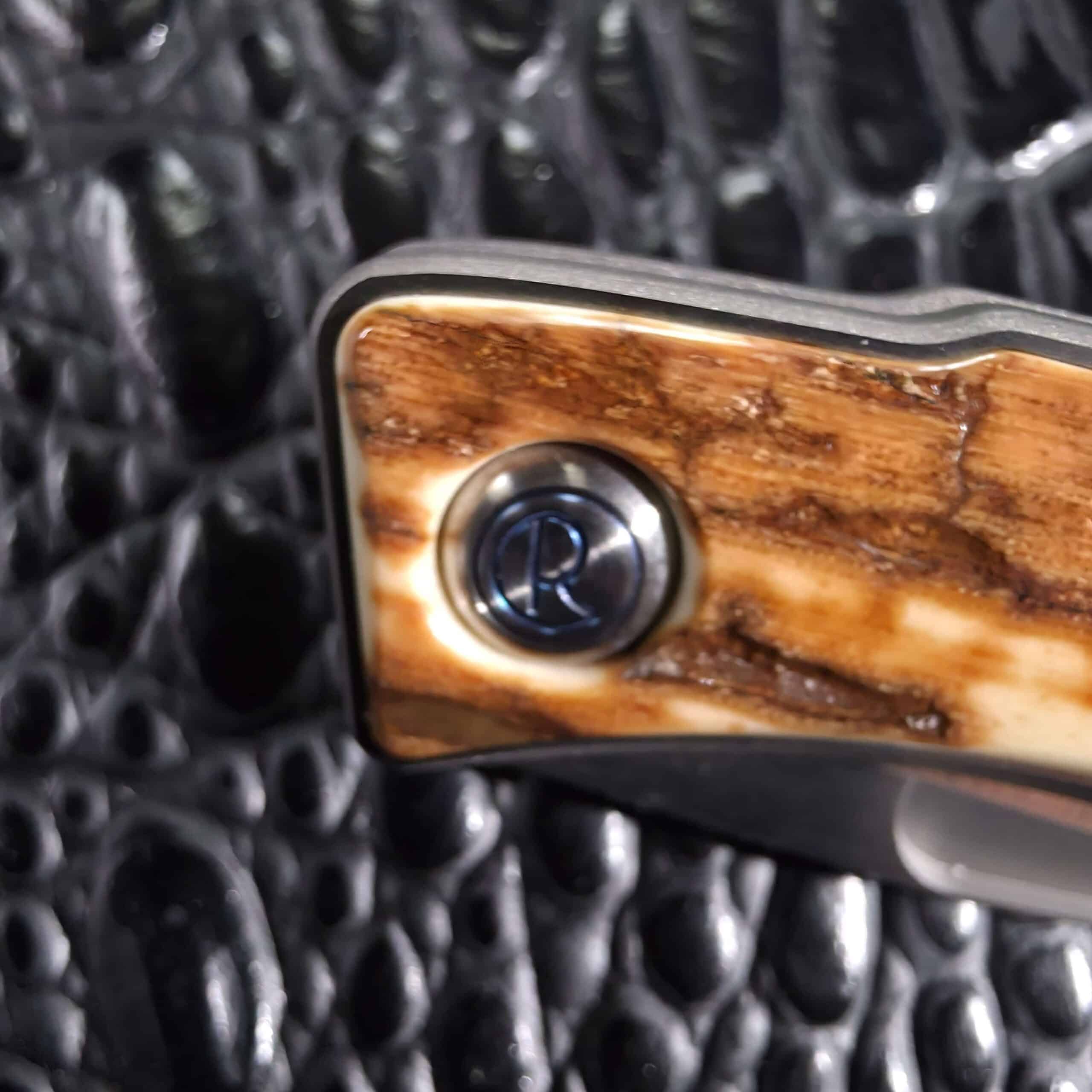 Blue anodized Chris Reeve pivot medallion set into mammoth bark ivory