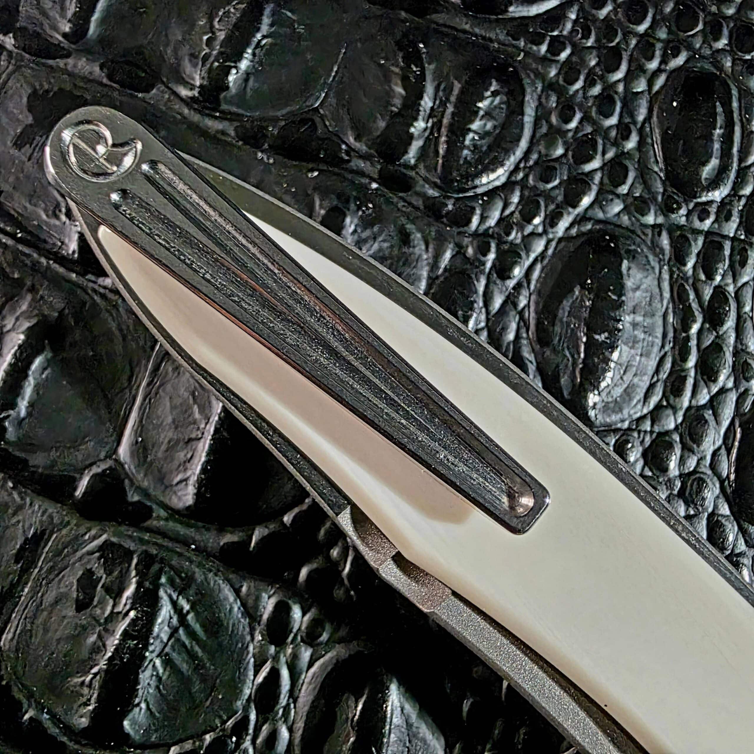Machined three-dimensional titanium pocket clip on the Chris Reeve Mnandi with the Chris Reeve logo at the butt end