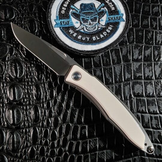 Chris Reeve Mnandi open on black crocodile leather with white mammoth ivory inlays and hand-rubbed CPM S35VN blade