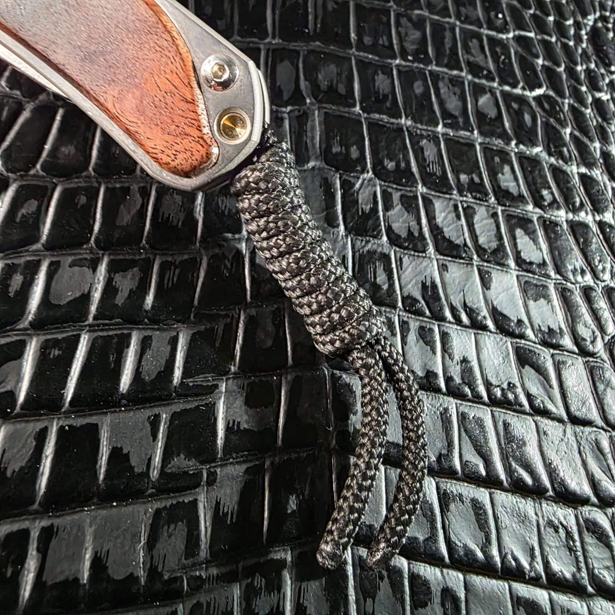 Black cord lanyard fitted to the lanyard port of the Chris Reeve Small Sebenza 2010 Annual Limited Edition