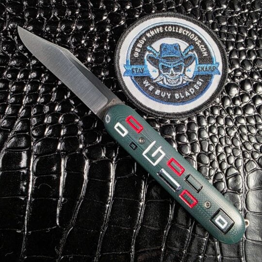 Chuck Gedraitis Switch Army Switchblade open show side with milled green G-10 mosaic and Nitro-V spear point blade