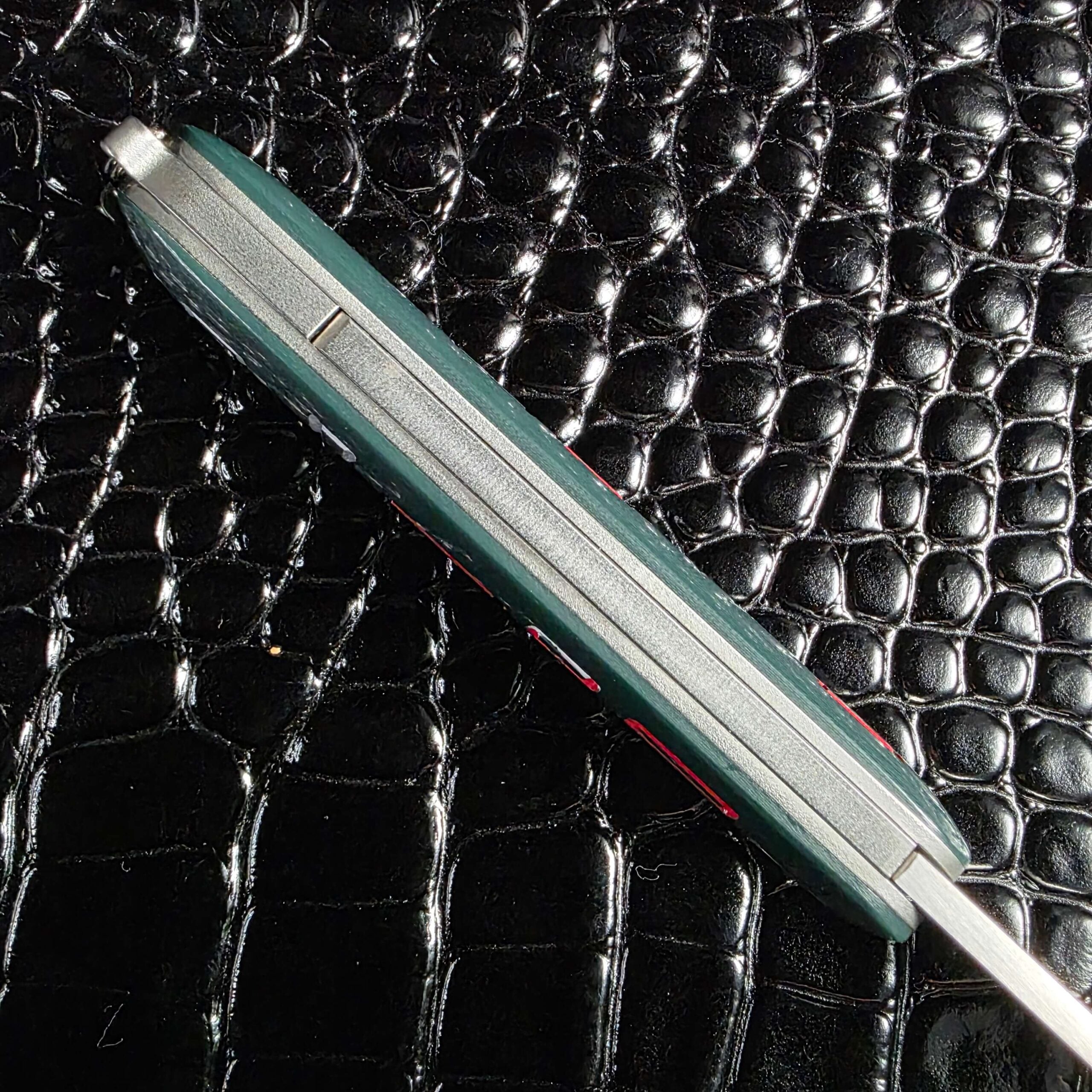 Titanium liners and spacer visible along the spine of the Chuck Gedraitis Switch Army Switchblade