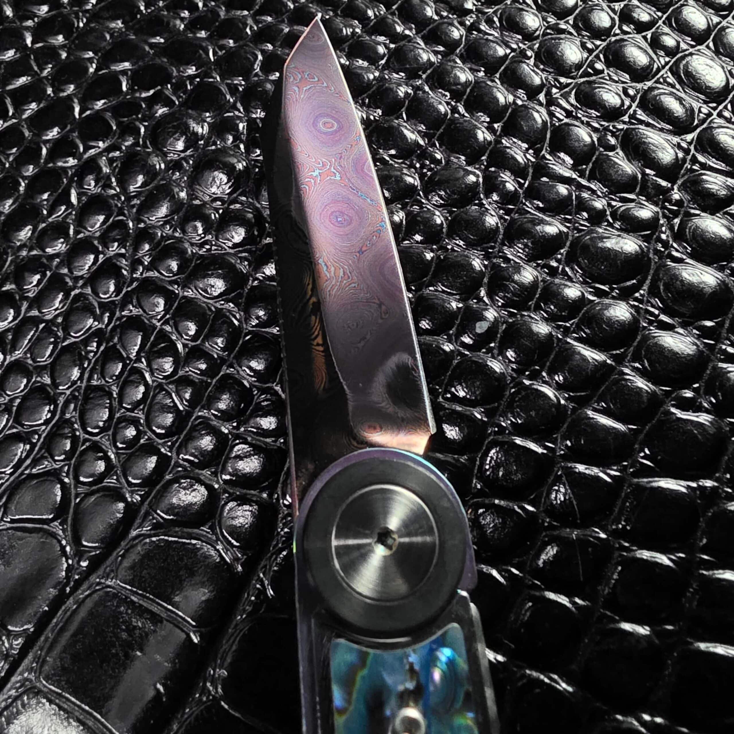 Full length of the Dew Hara Infinity damascus blade shown vertically