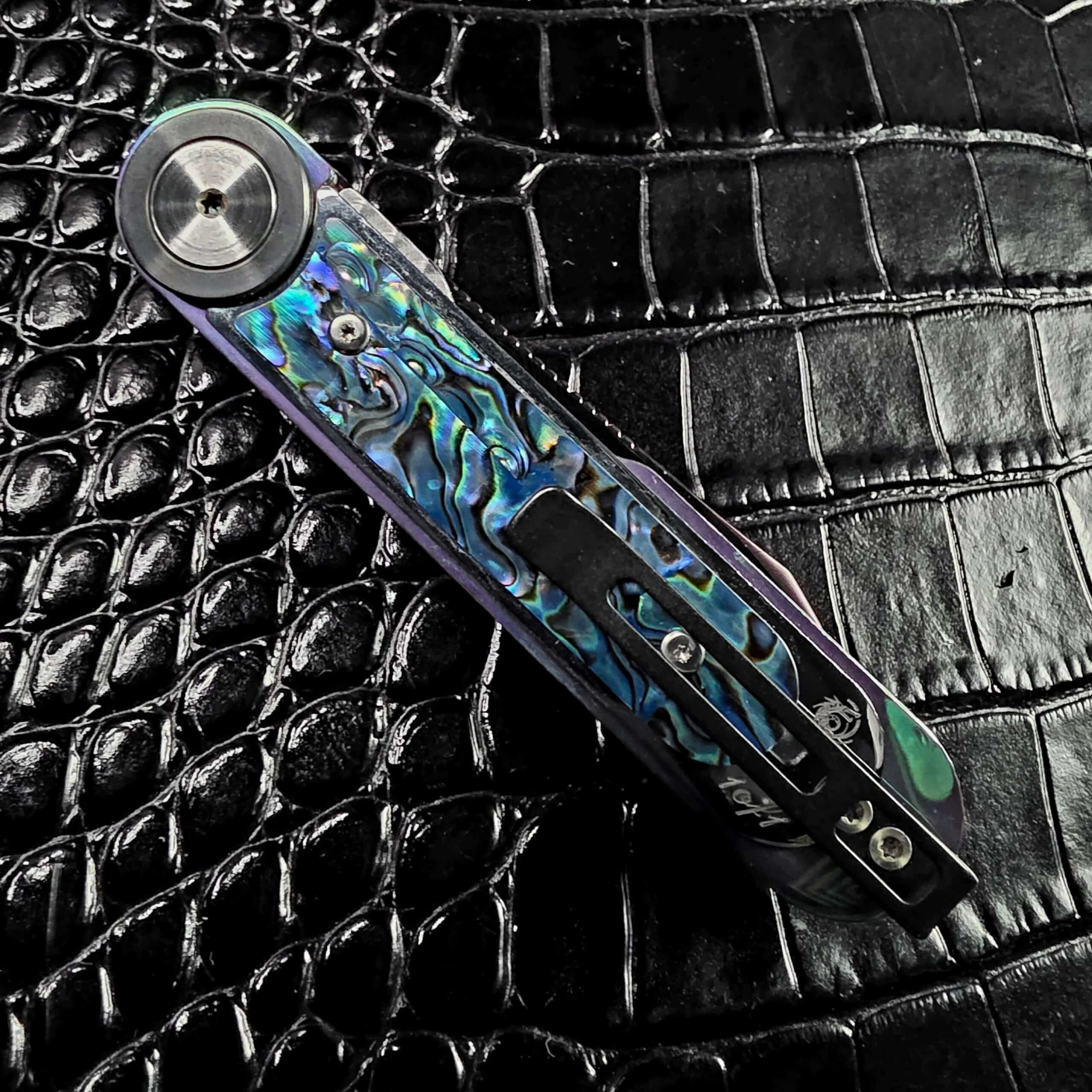 Dew Hara Infinity closed on the clip side with the pocket clip over the abalone panel