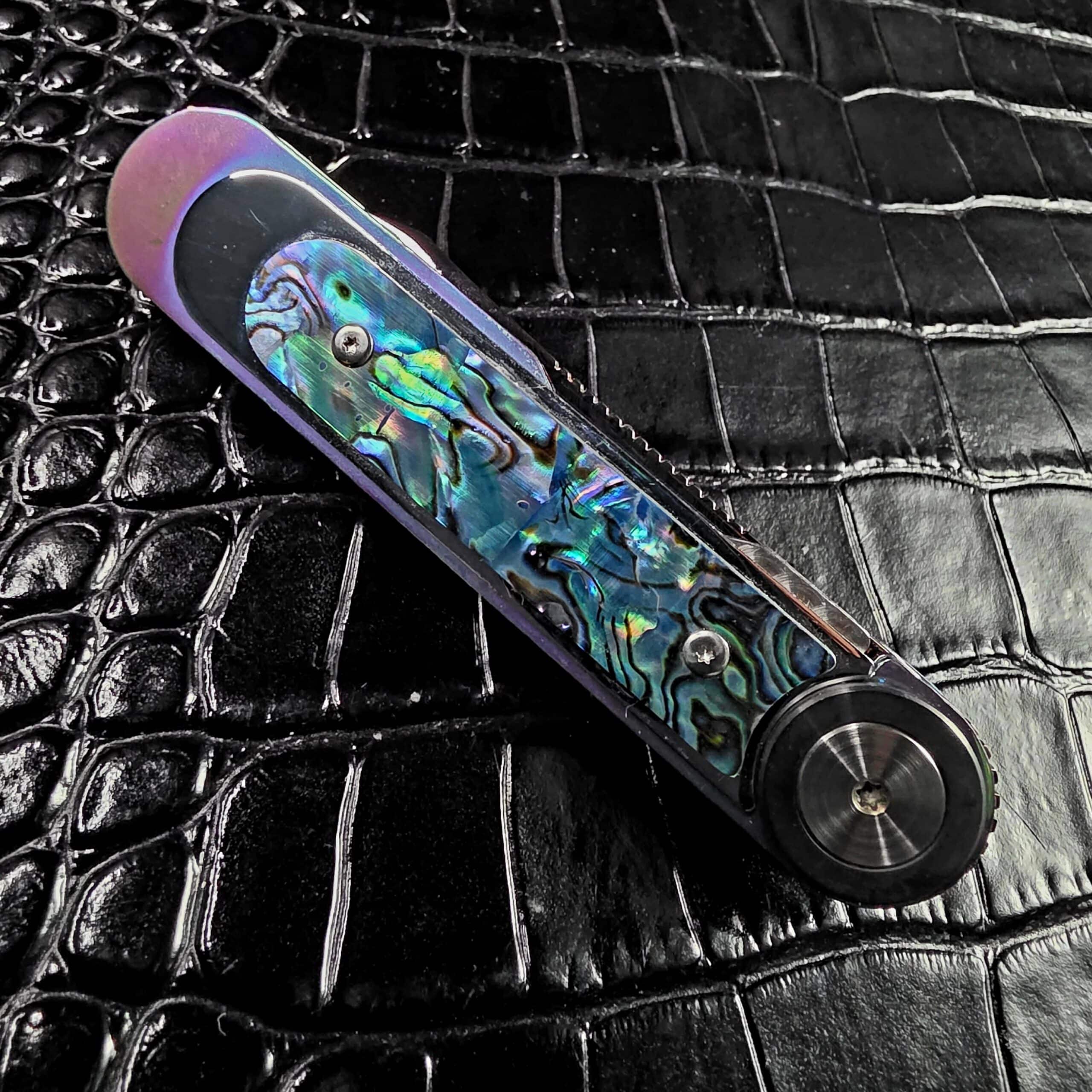 Dew Hara Infinity closed on the show side, abalone scale and jimped blade spine