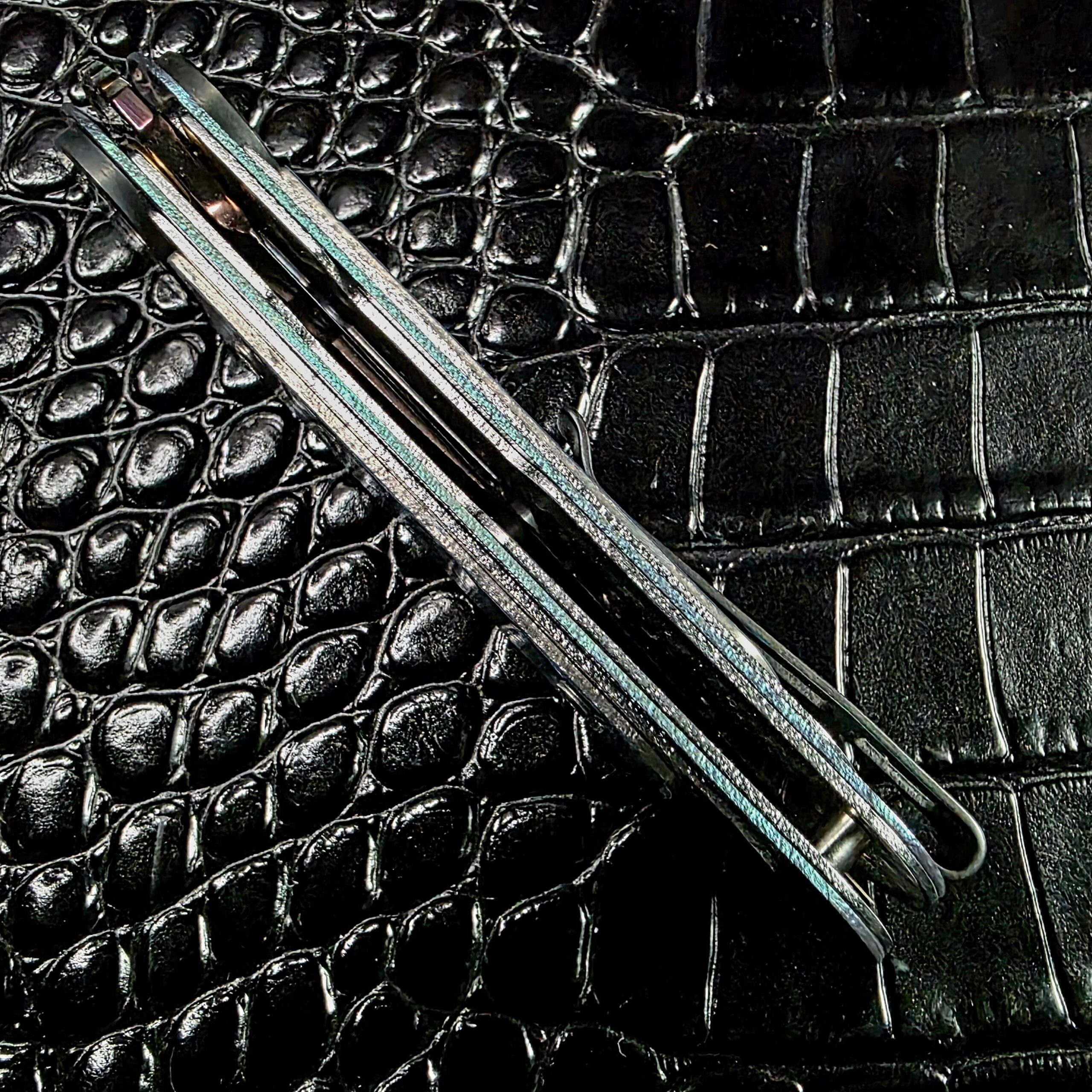 Opal anodized titanium frame edge on the Dew Hara Infinity in teal and violet