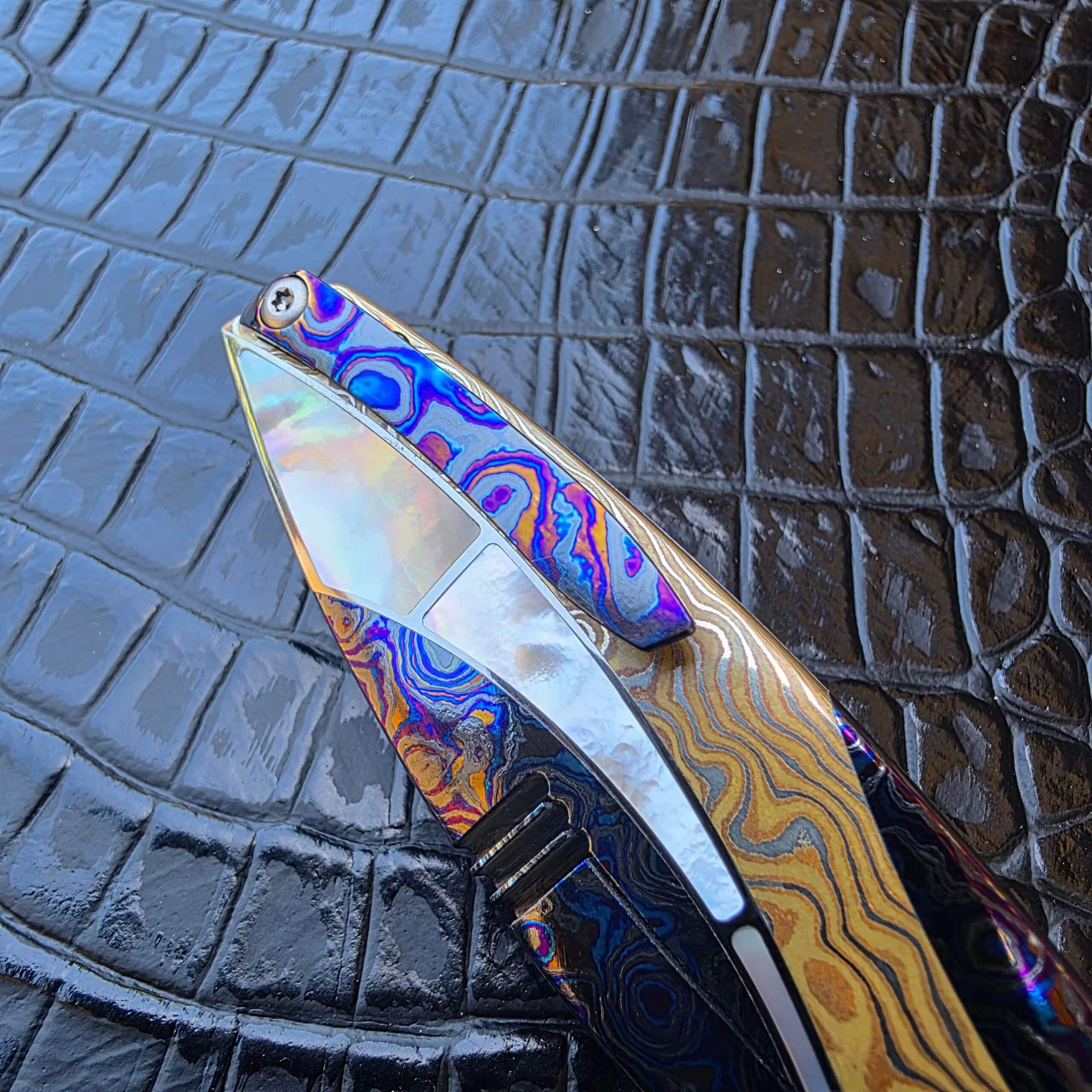 Mother-of-pearl accent set between ZircuTi and Copper Damascus on the FengLi Jiao Yue