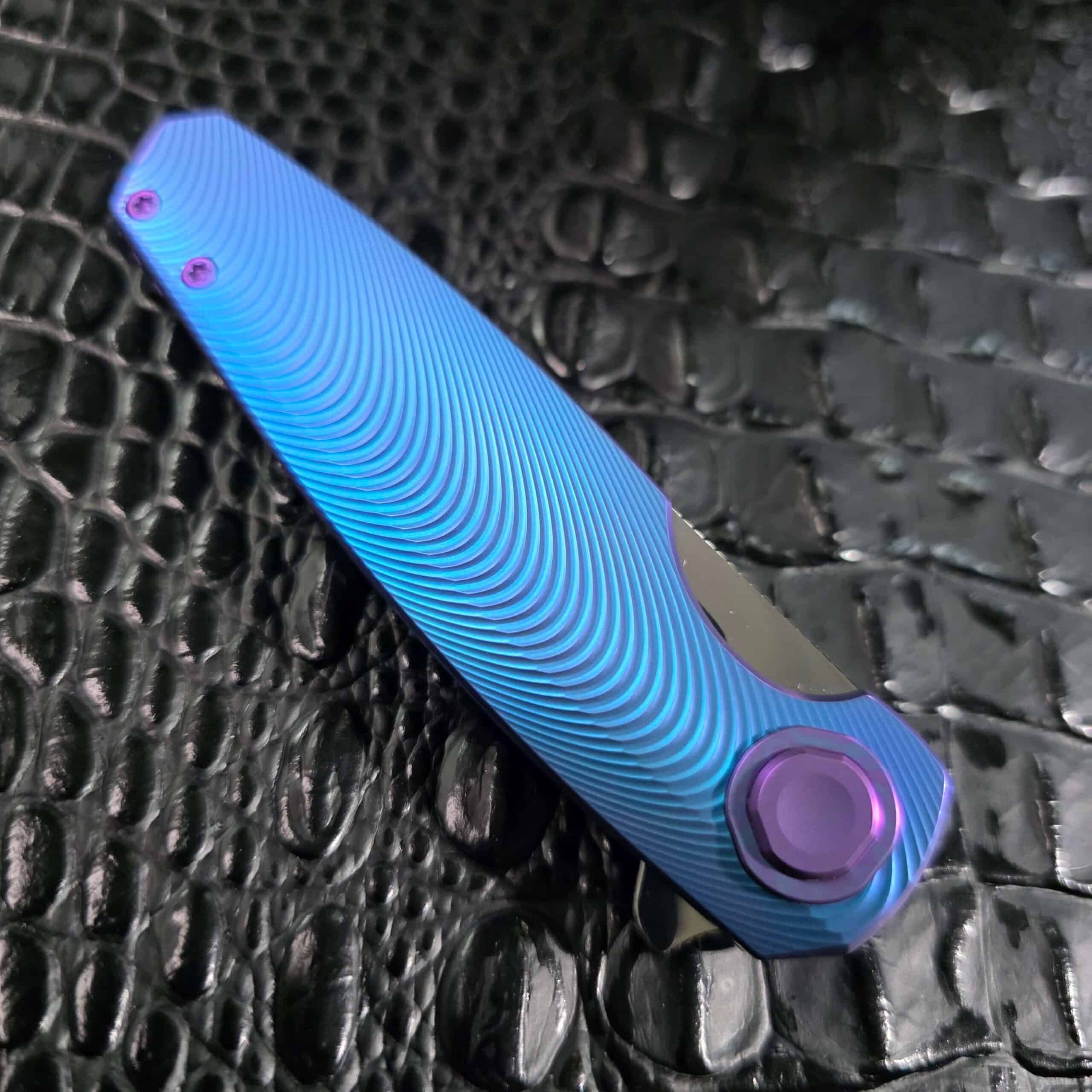 Closed Holt Bladeworks Morpheus #1856 showing the full 3D-milled Triad pattern across the anodized titanium scale