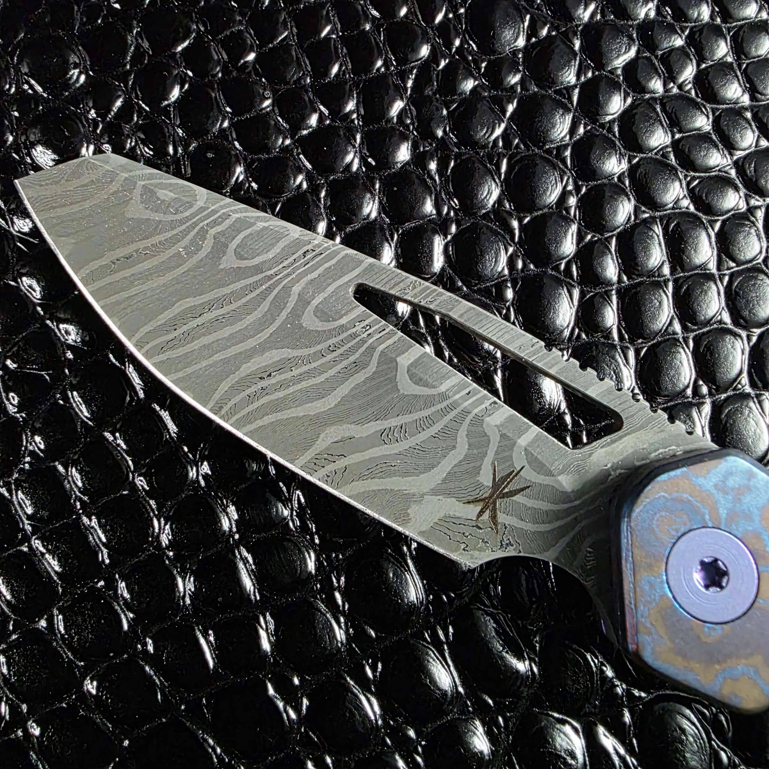 Keanison Knives maker's mark etched into the Fireclone 2 damascus blade