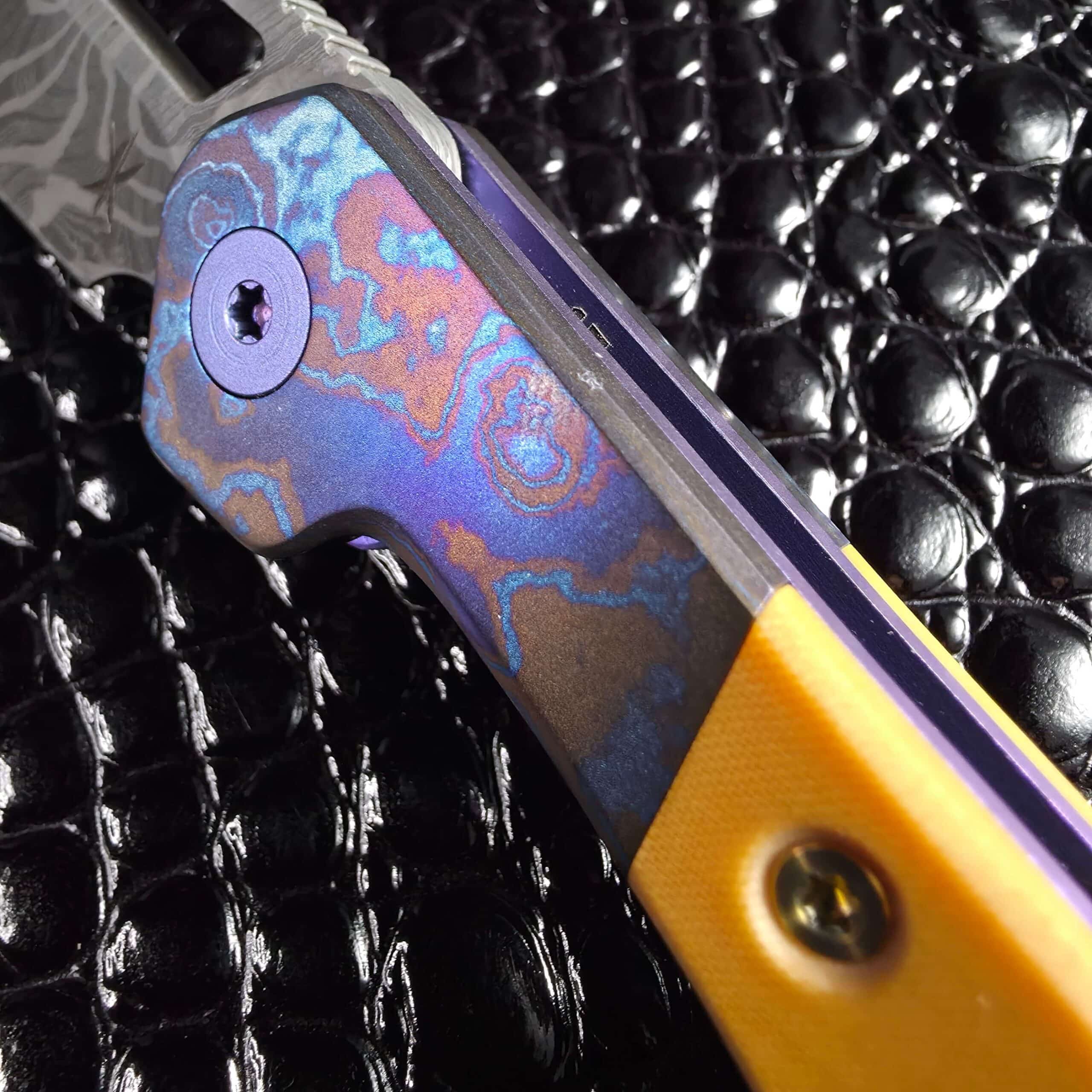 Macro of Radmascus pattern welded titanium bolster in blue copper and violet