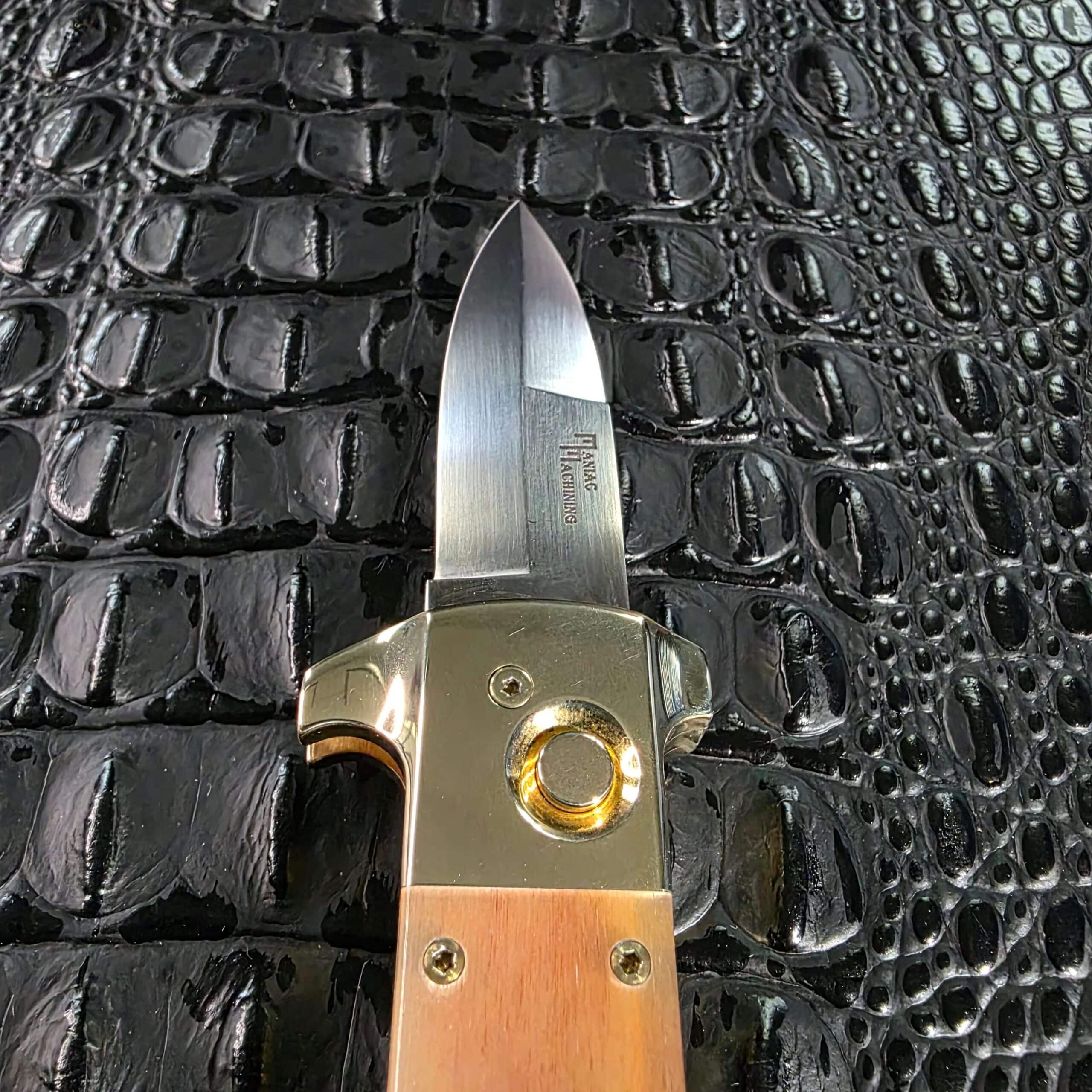Straight-on view of the open blade and brass button on the Maniac Machining Stinger Classic