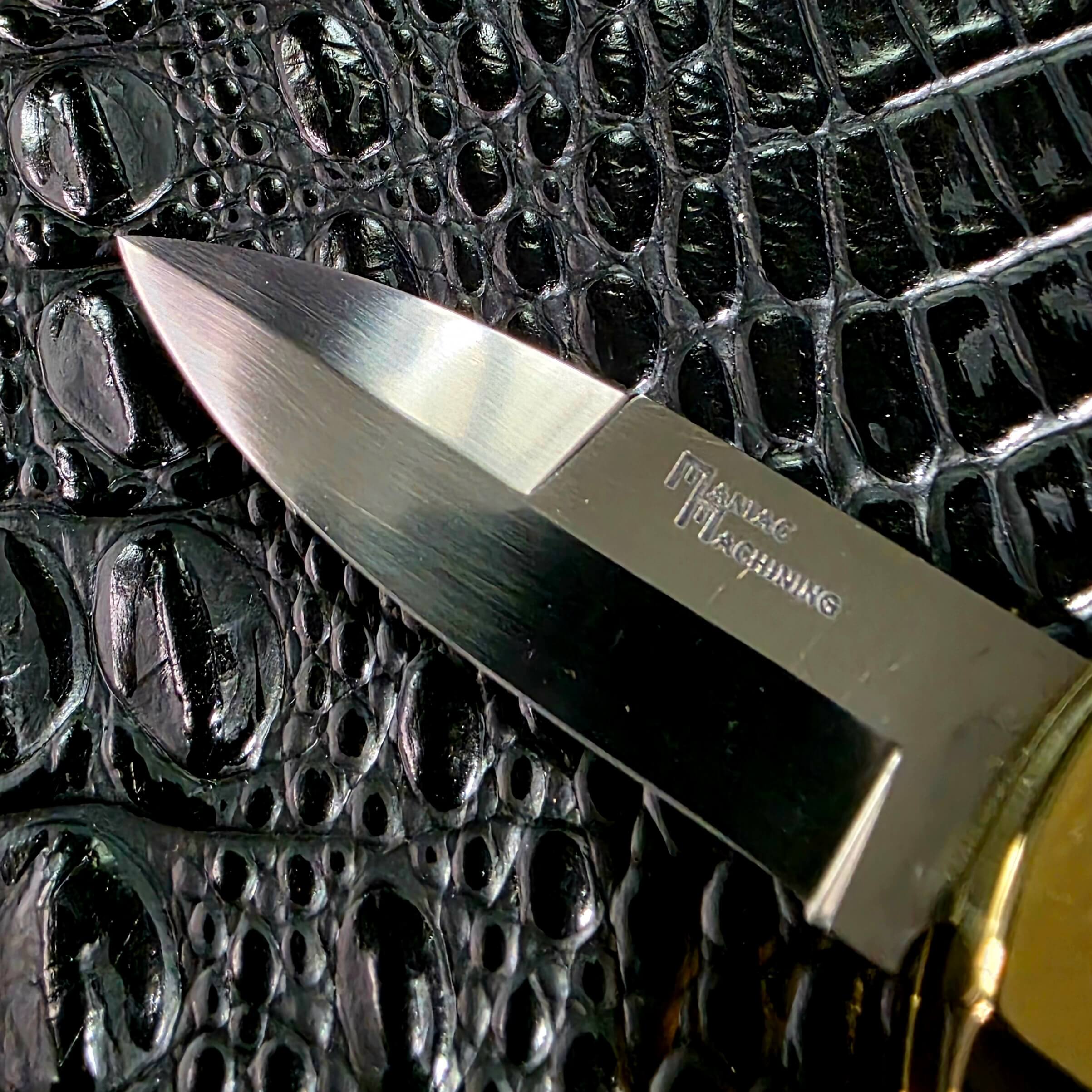 Diagonal view of the open Maniac Machining Stinger Classic with brass frame and yak horn scales