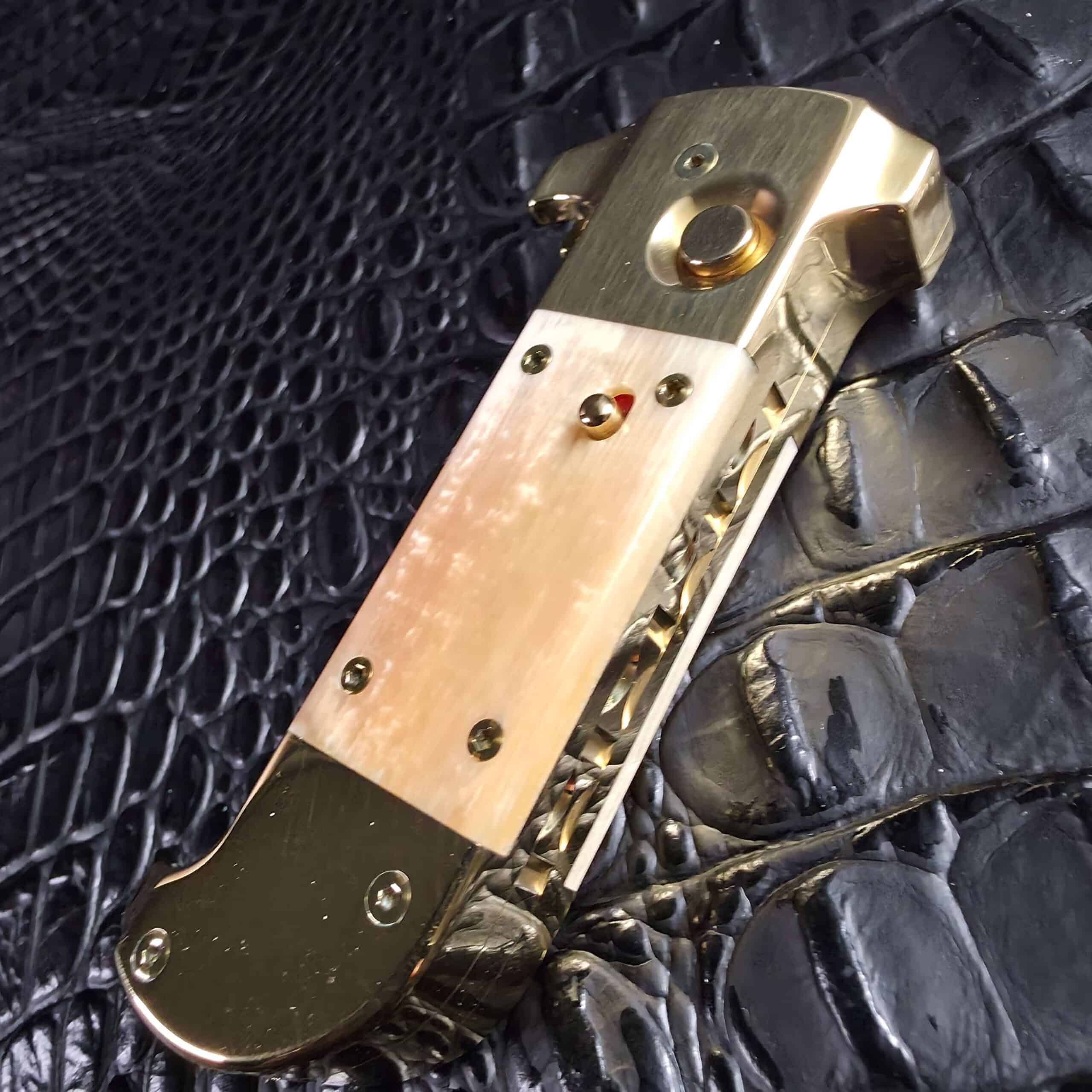 Closed Maniac Machining Stinger Custom showing brass firing button and mammoth ivory scale