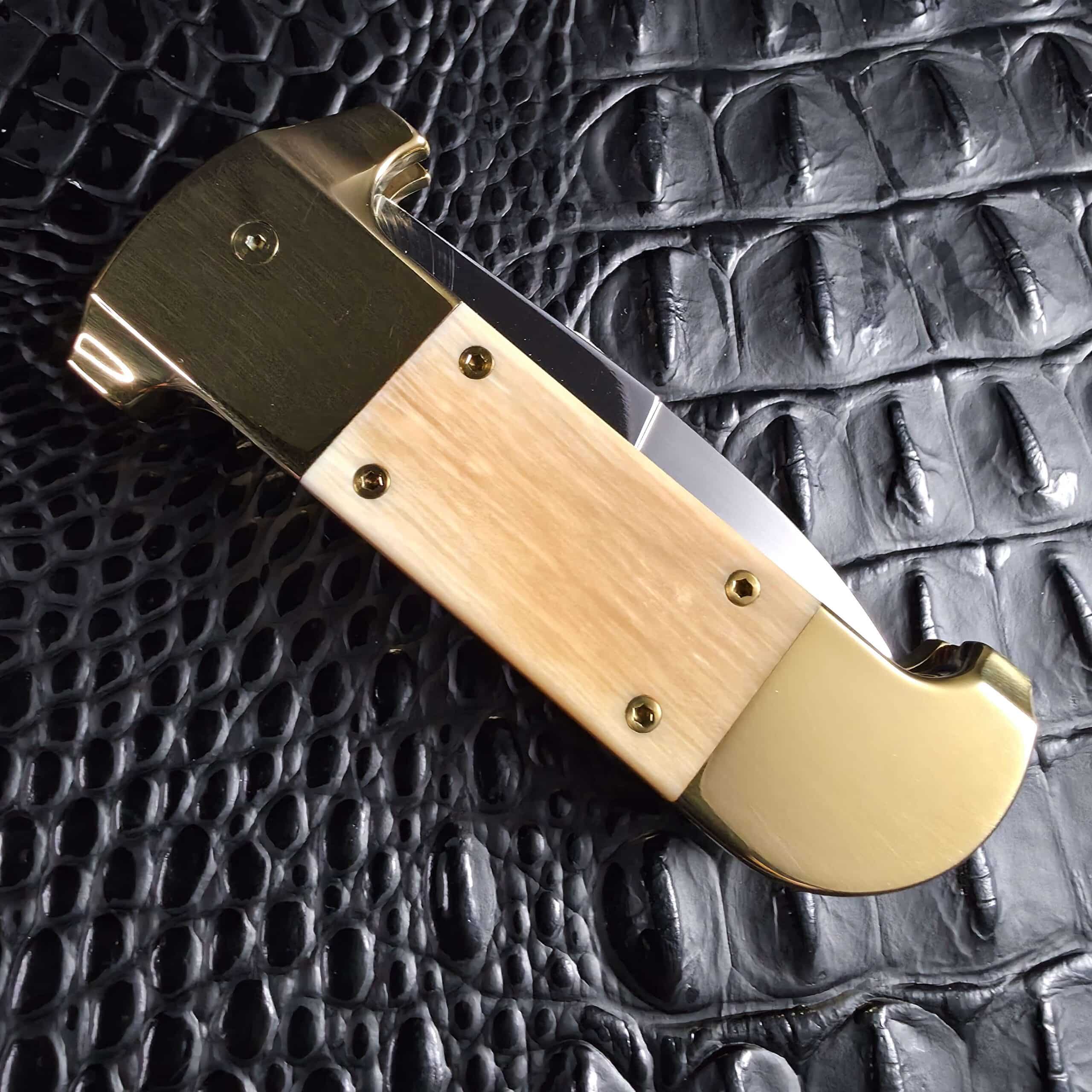 Clean reverse side of the closed Maniac Machining Stinger Custom in brass and mammoth ivory