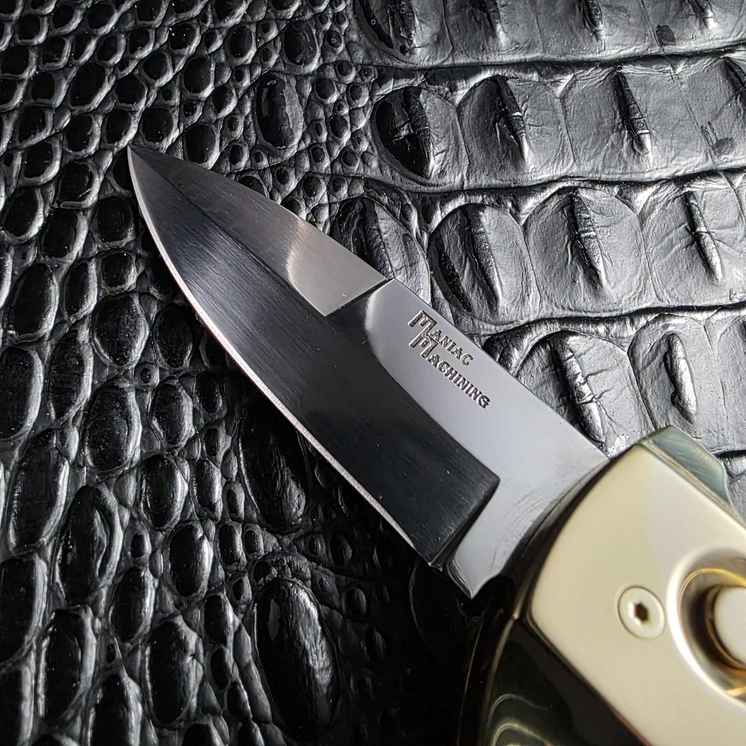 Mirror polished drop point blade with long swedge on a Maniac Machining Stinger Custom