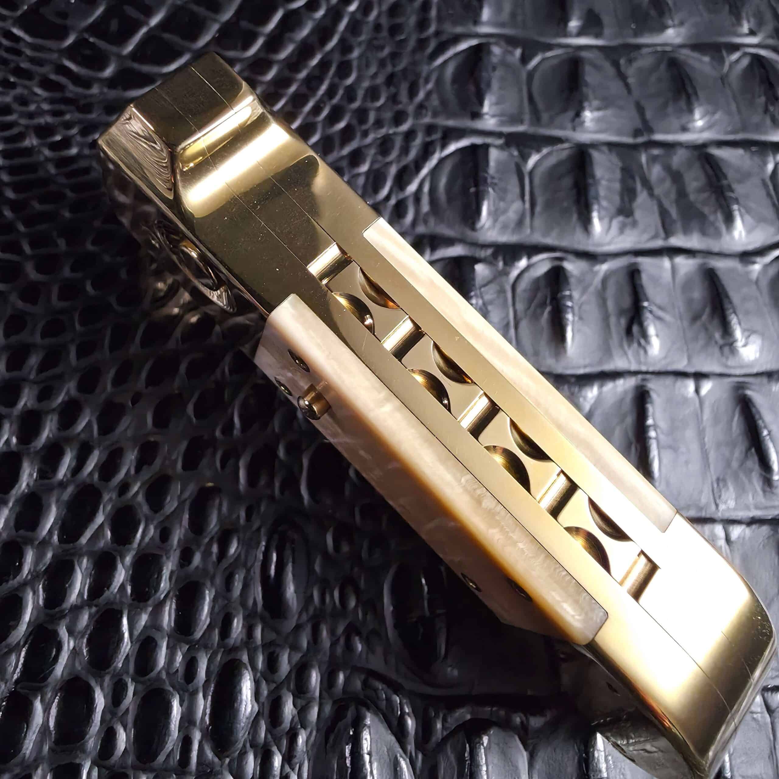 Hand-cut scalloped brass spine on the Maniac Machining Stinger Custom automatic