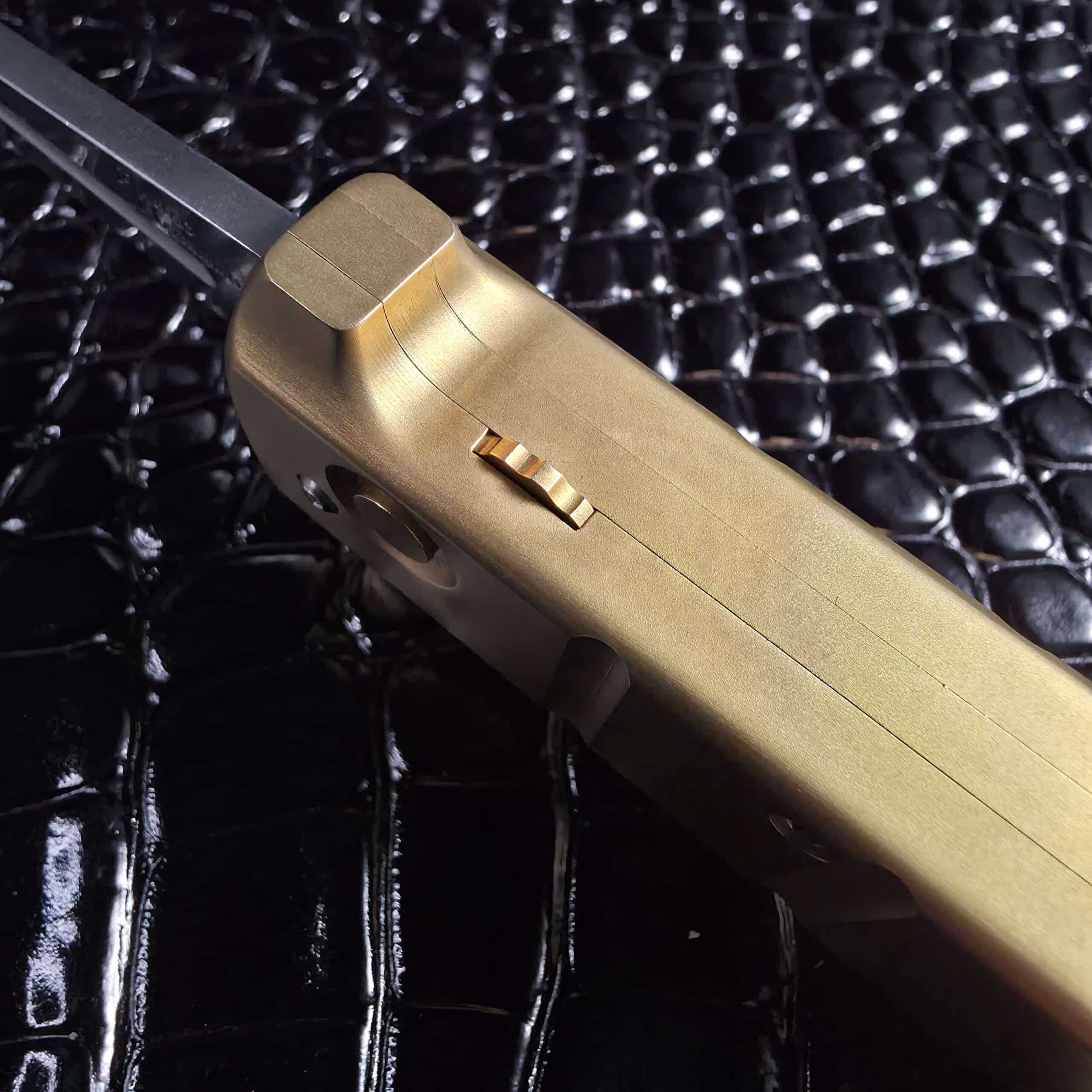 Brass sliding safety machined into the spine of the Maniac Machining Stinger EDC