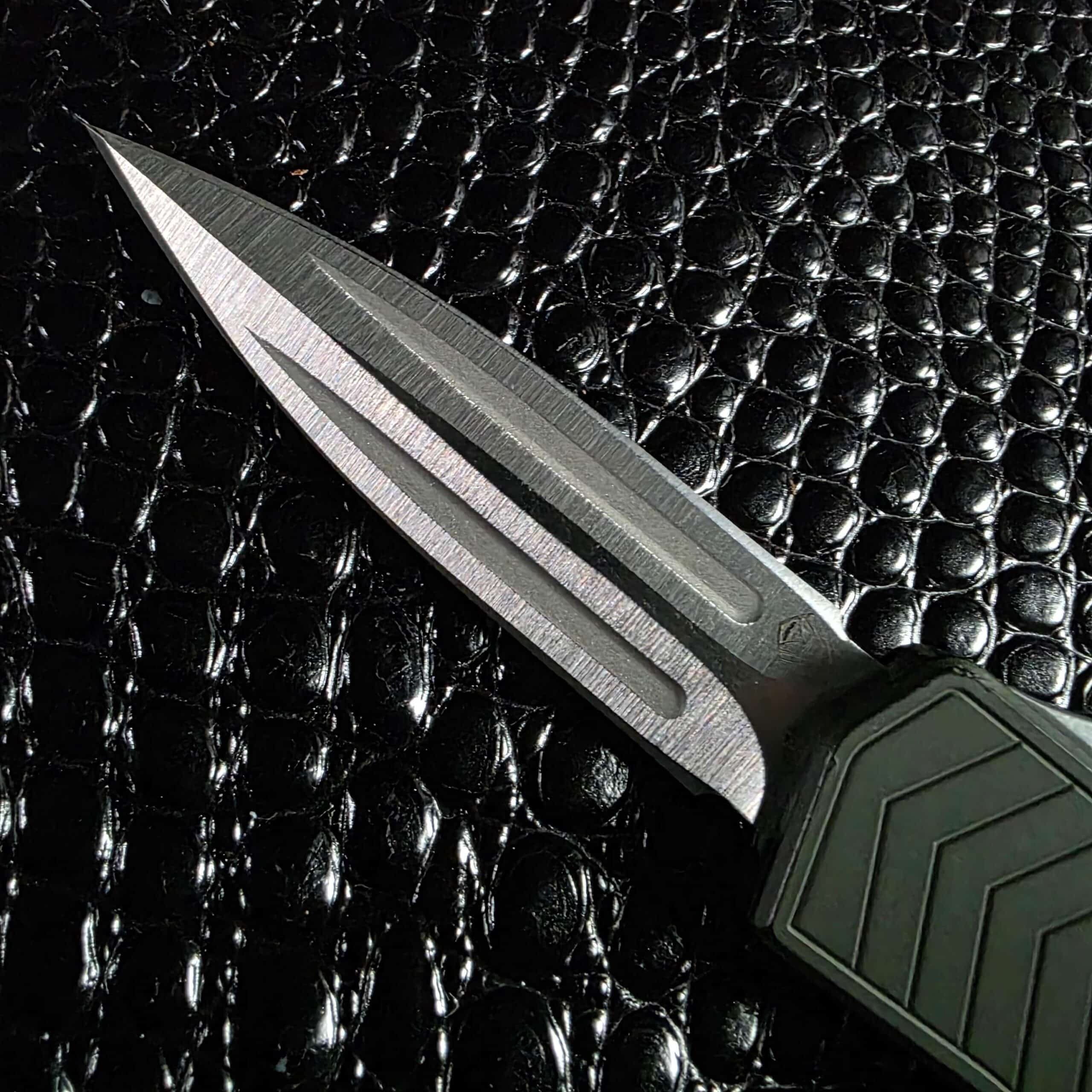 154CM double-edge dagger blade with twin fullers and tumbled finish on the Medford Merc-1