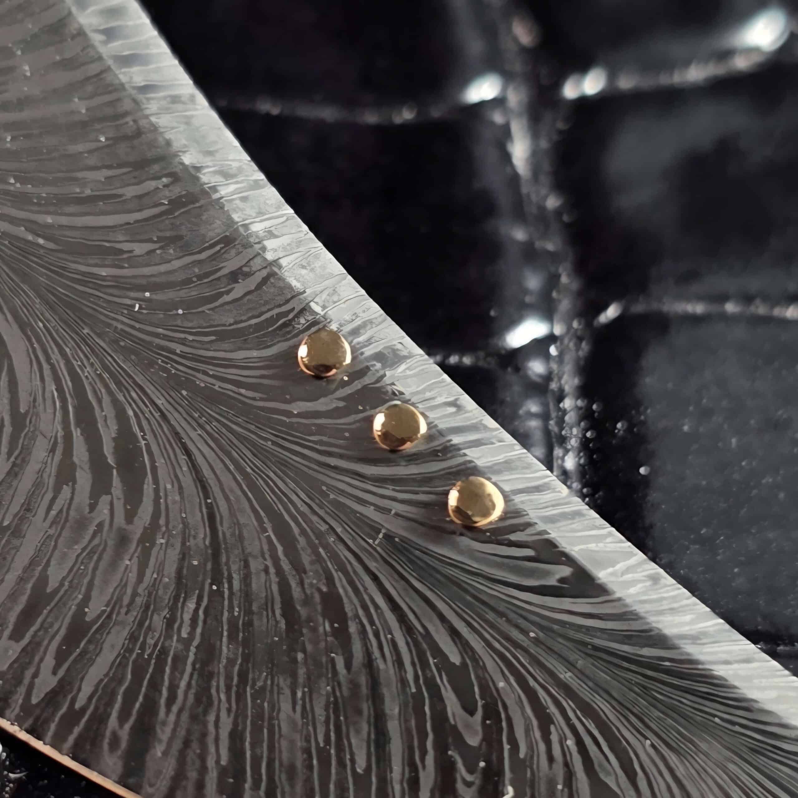 Three 14K gold dots inset along the spine of the Scott Gallagher feather damascus blade