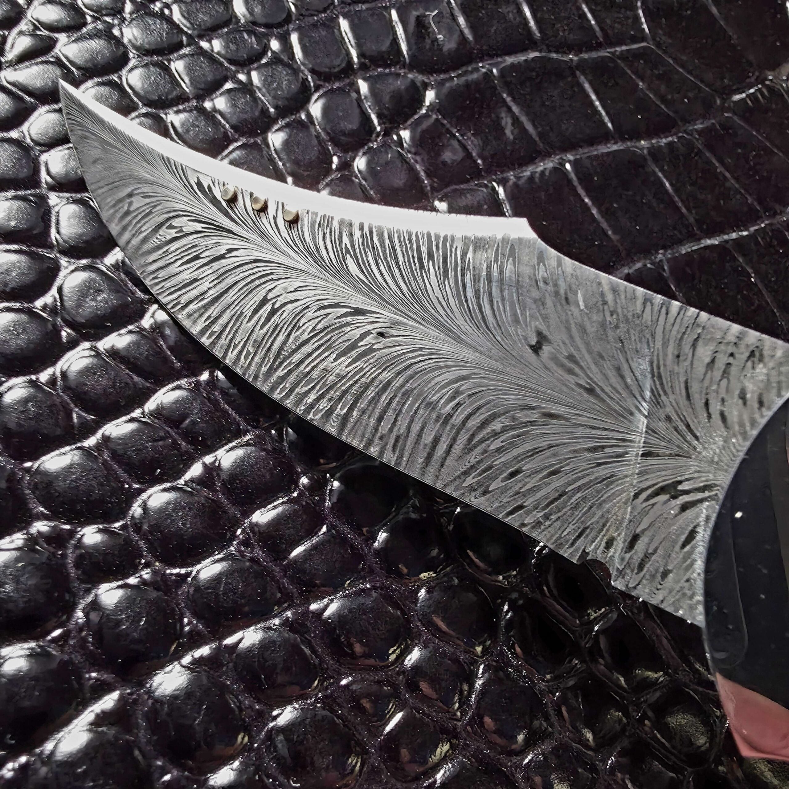 Macro of the in-house forged feather damascus pattern on the Scott Gallagher Escalante folder blade