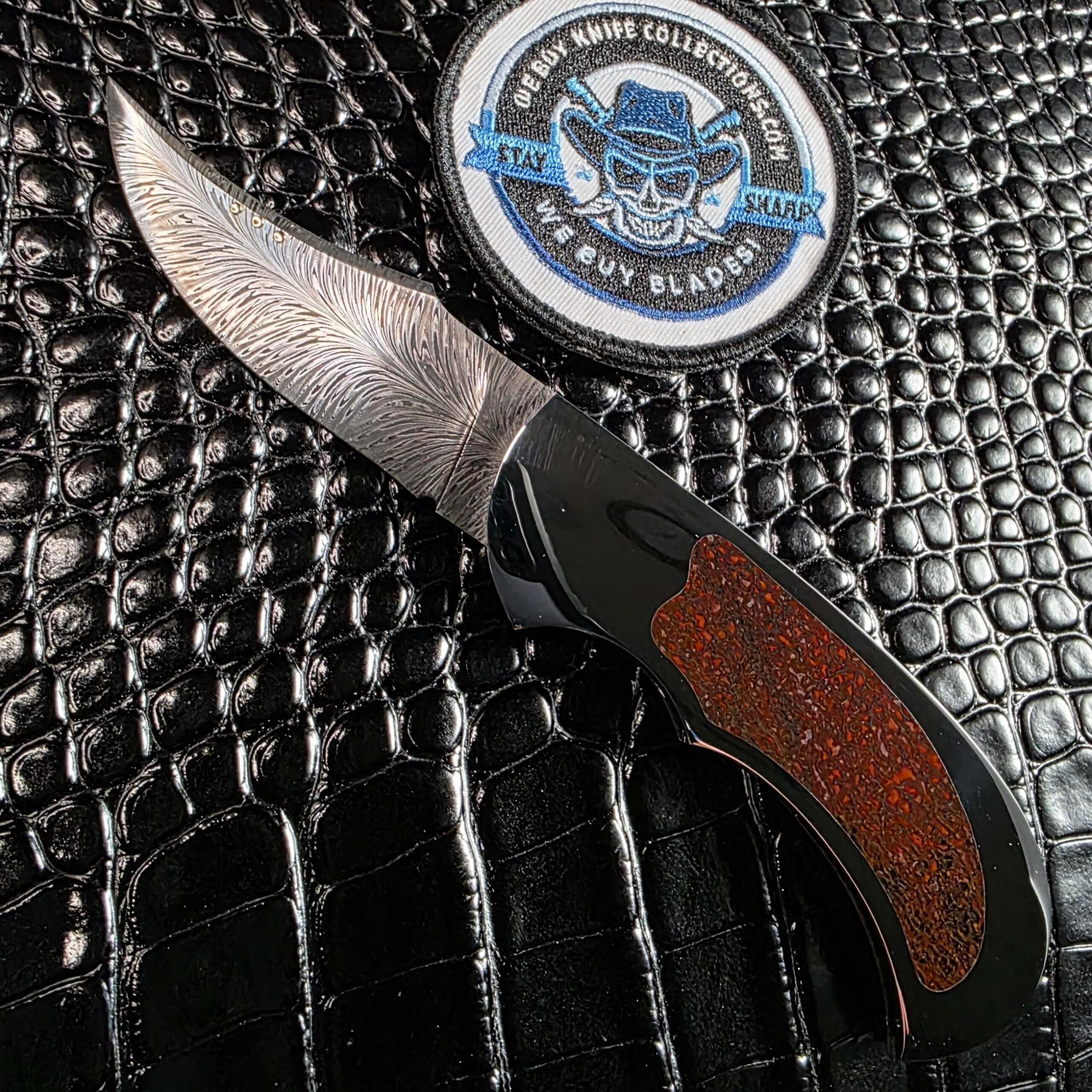 Scott Gallagher Escalante Inter Frame Folder open showing feather damascus blade and red dinosaur bone inlay
