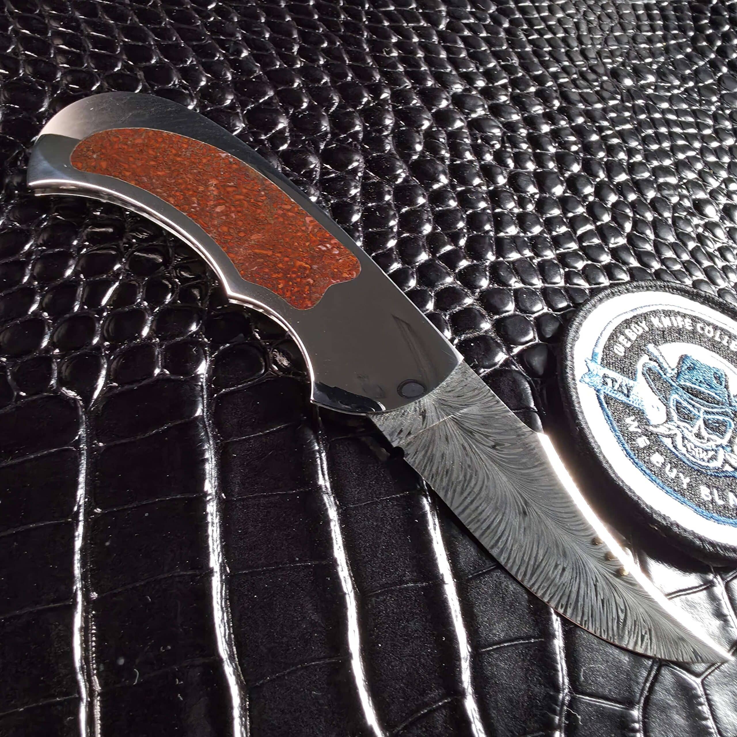 Scott Gallagher Escalante Inter Frame Folder open showing 416 stainless frame and inlaid red dinosaur bone