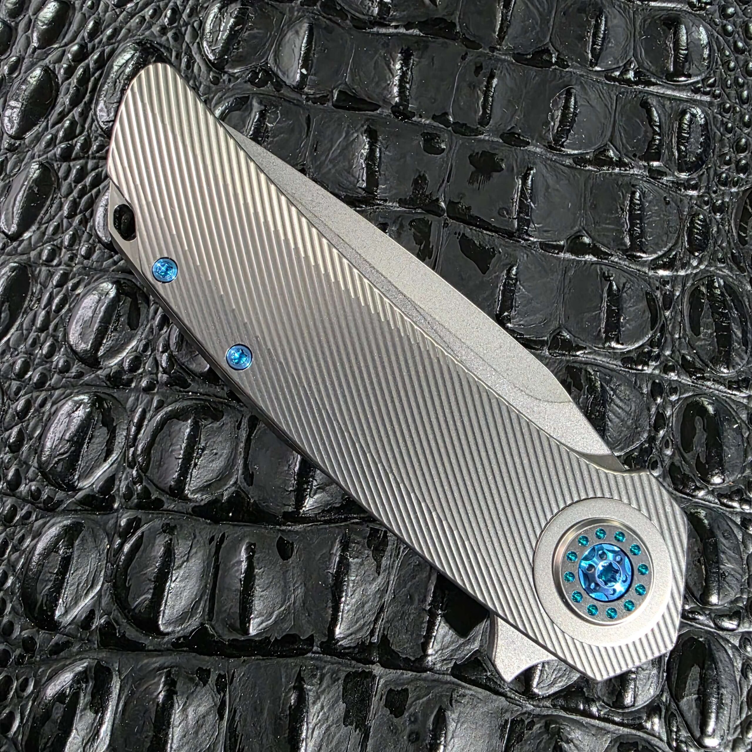 Closed show side of the Skiff Made Blades Fugitive #0113 showing the full milled titanium scale and anodized hardware