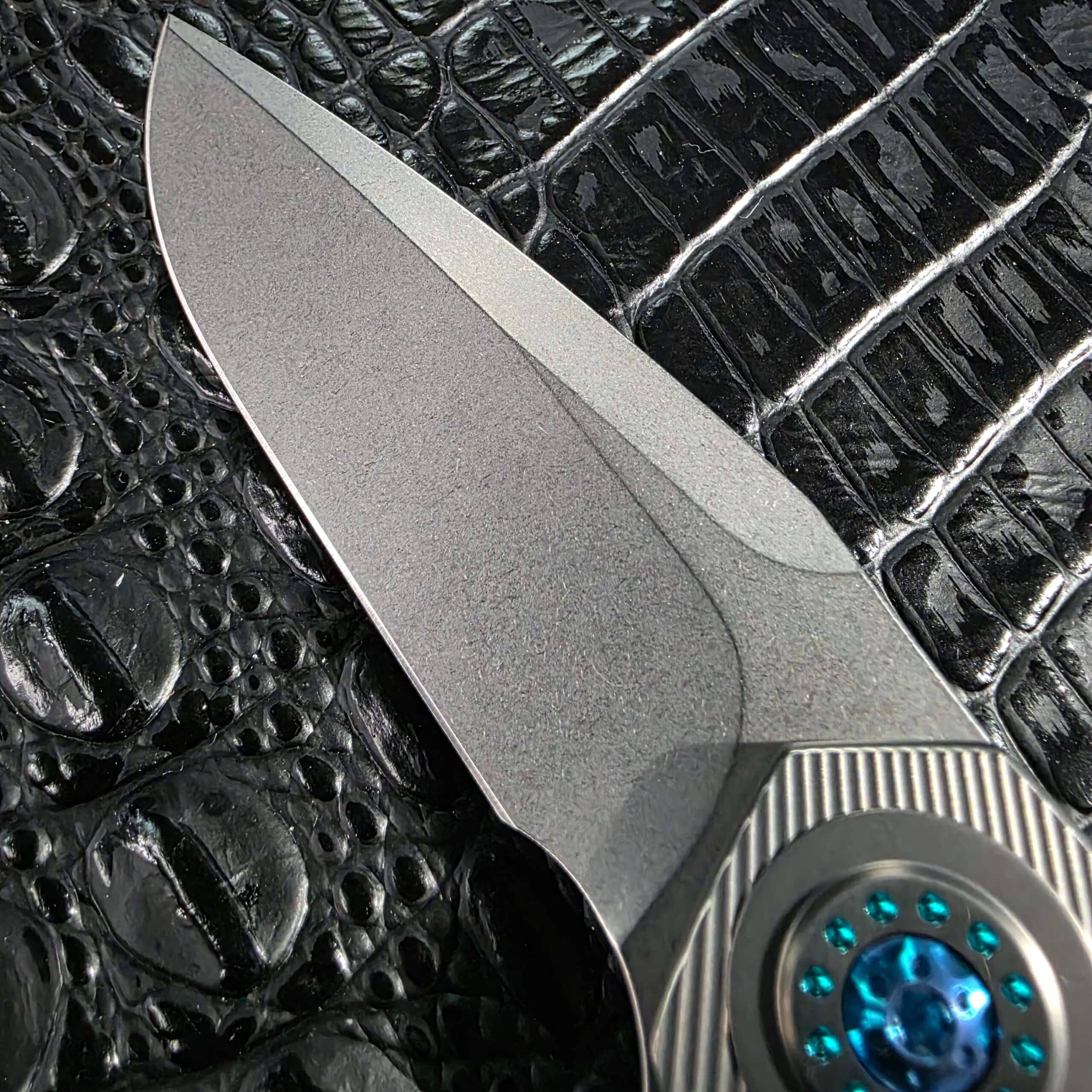 Macro of the stonewashed Uddeholm Elmax blade on the Skiff Made Blades Fugitive #0113 showing the grind and swedge
