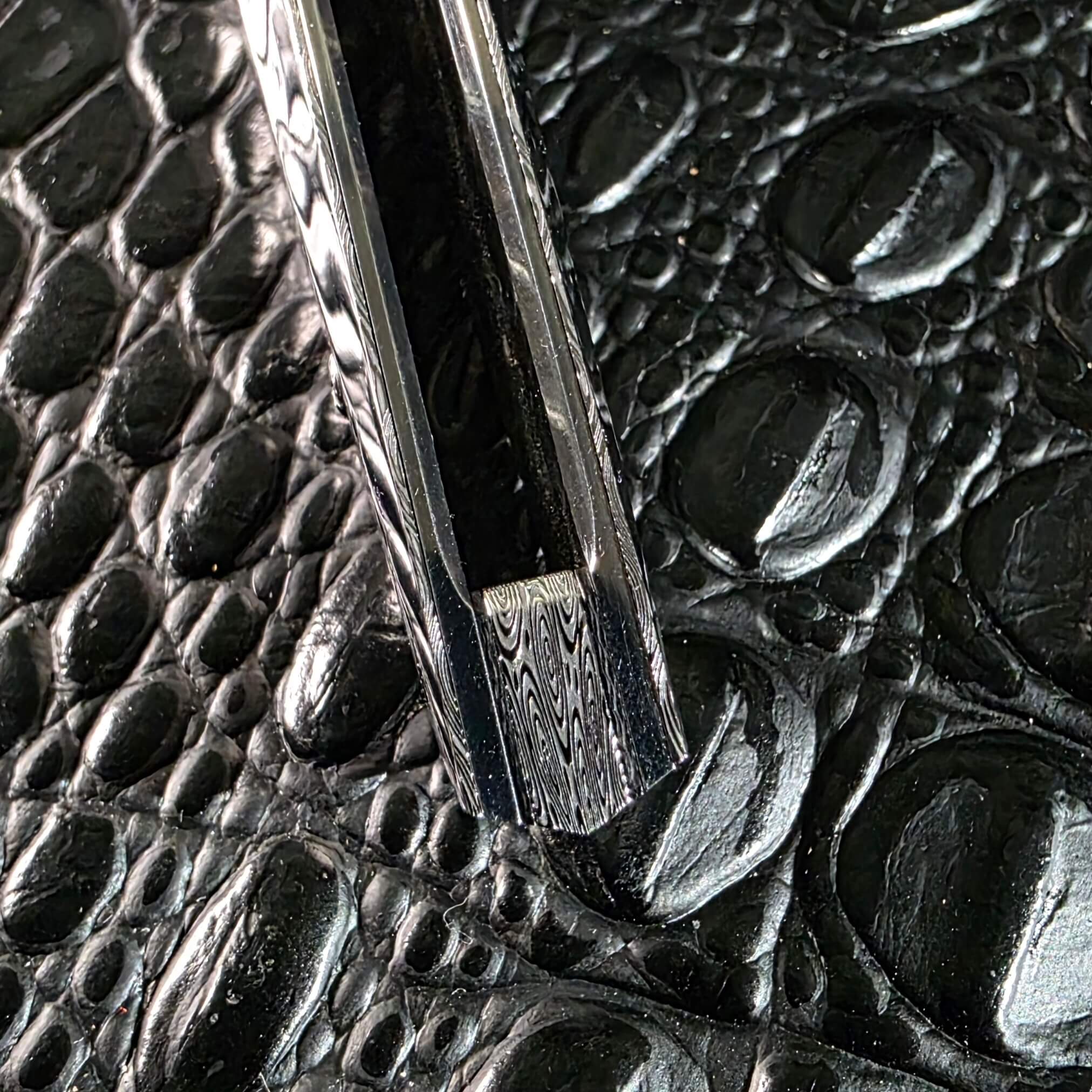 Butt-end detail of the Stefano Compostella StriaXL showing the matching Damasteel Ladder backspacer between titanium liners