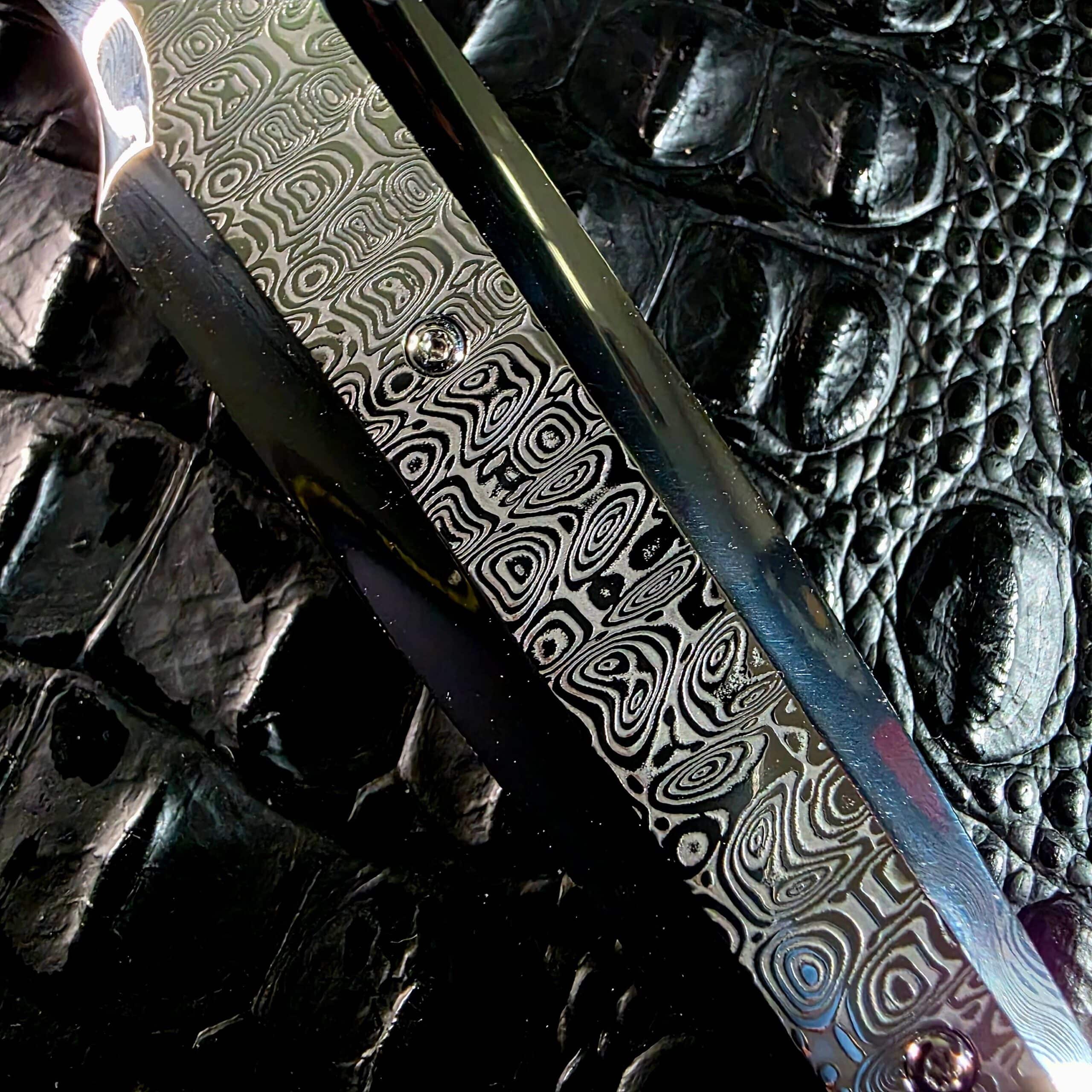 Macro photograph of the Damasteel Ladder stainless Damascus pattern on the Stefano Compostella StriaXL handle scale