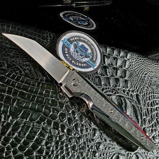 Stefano Compostella StriaXL custom flipper open on black crocodile leather with mirror-polished Damasteel Ladder scales and satin Erasteel APZ10 blade