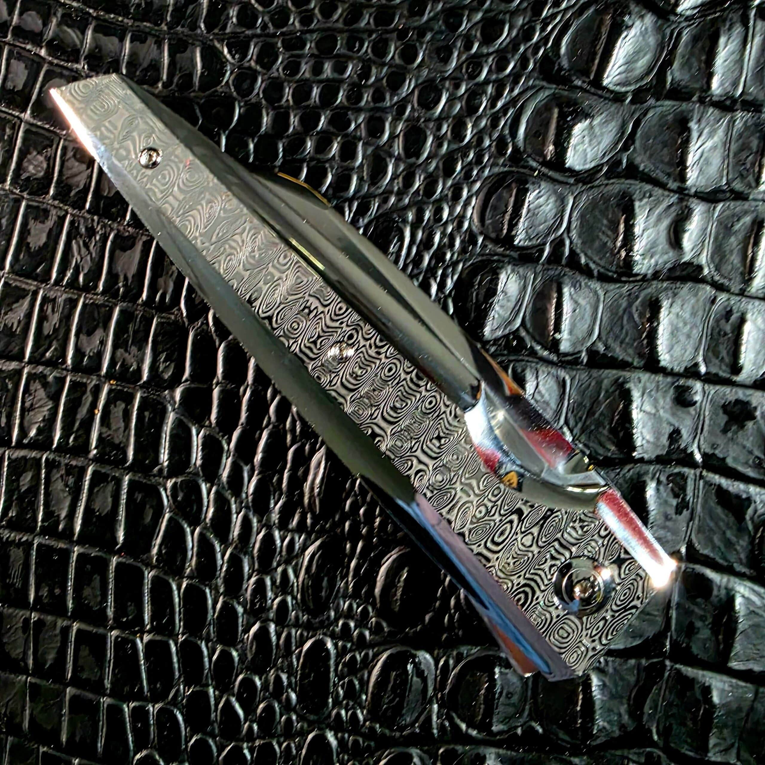 Spine view of the closed Stefano Compostella StriaXL showing the titanium 6Al4V liner between Damasteel Ladder scales