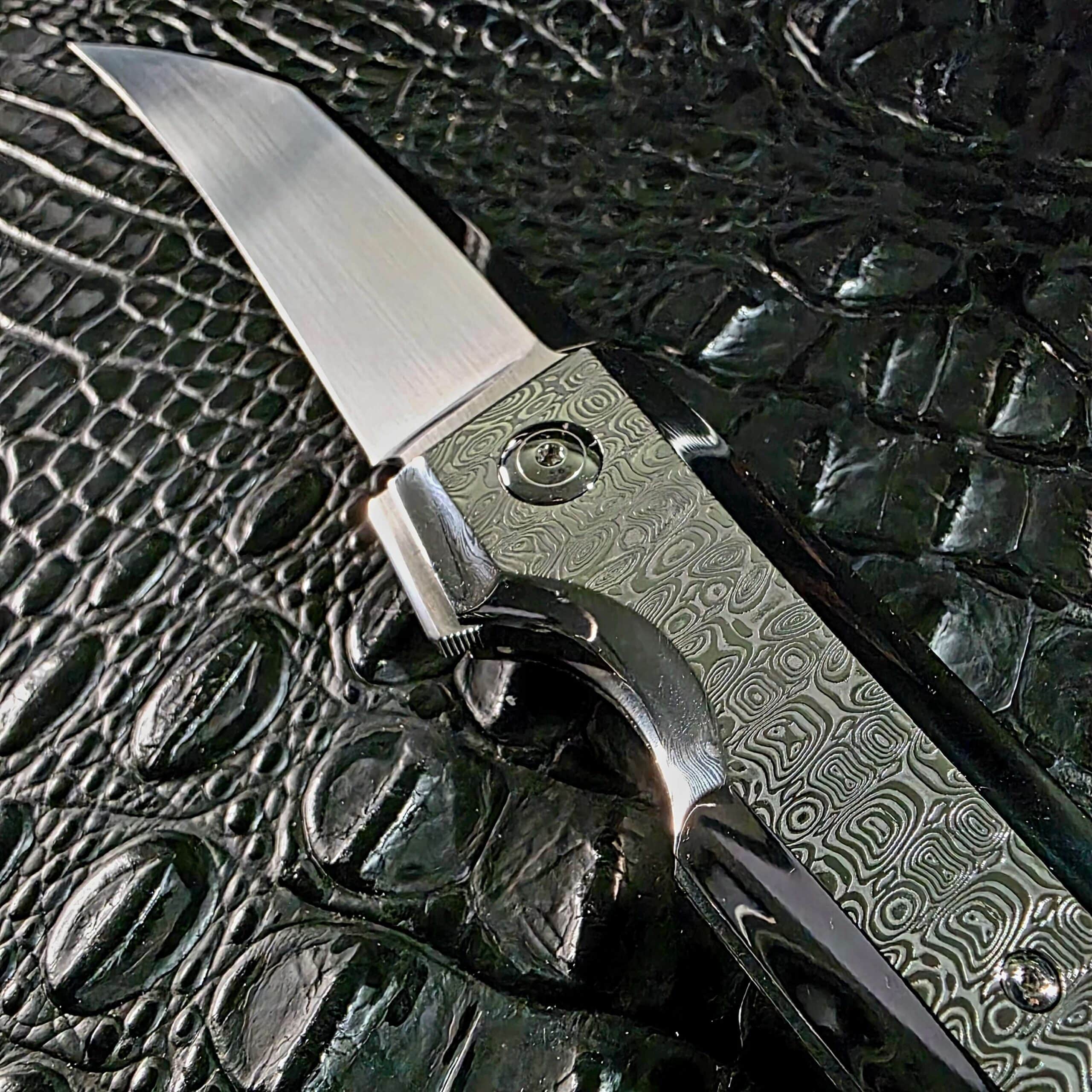 Upright display view of the Stefano Compostella StriaXL showing the full Damasteel Ladder handle profile and titanium frame