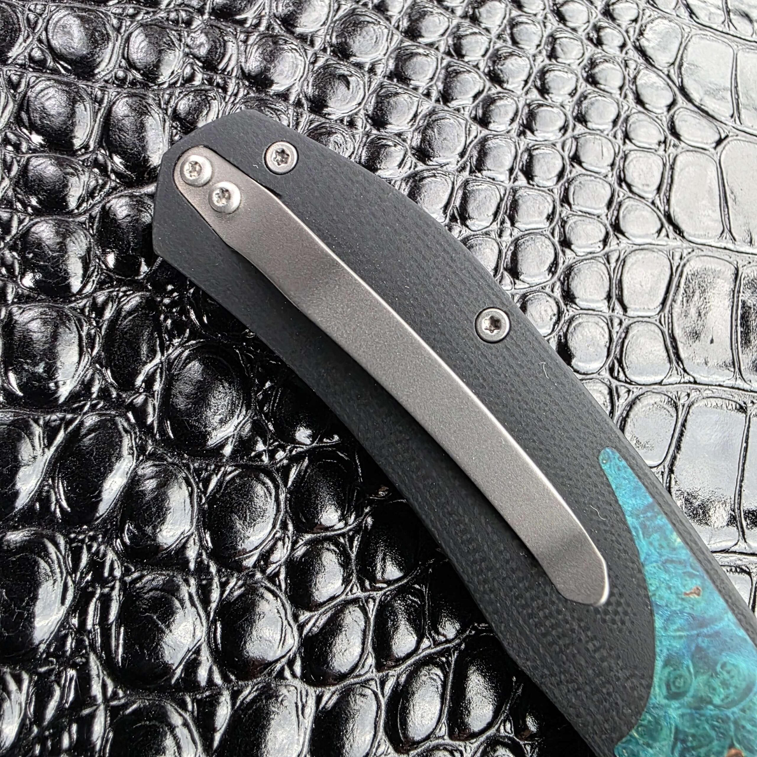 Titanium pocket clip and mounting screws on the 3LegDog M10