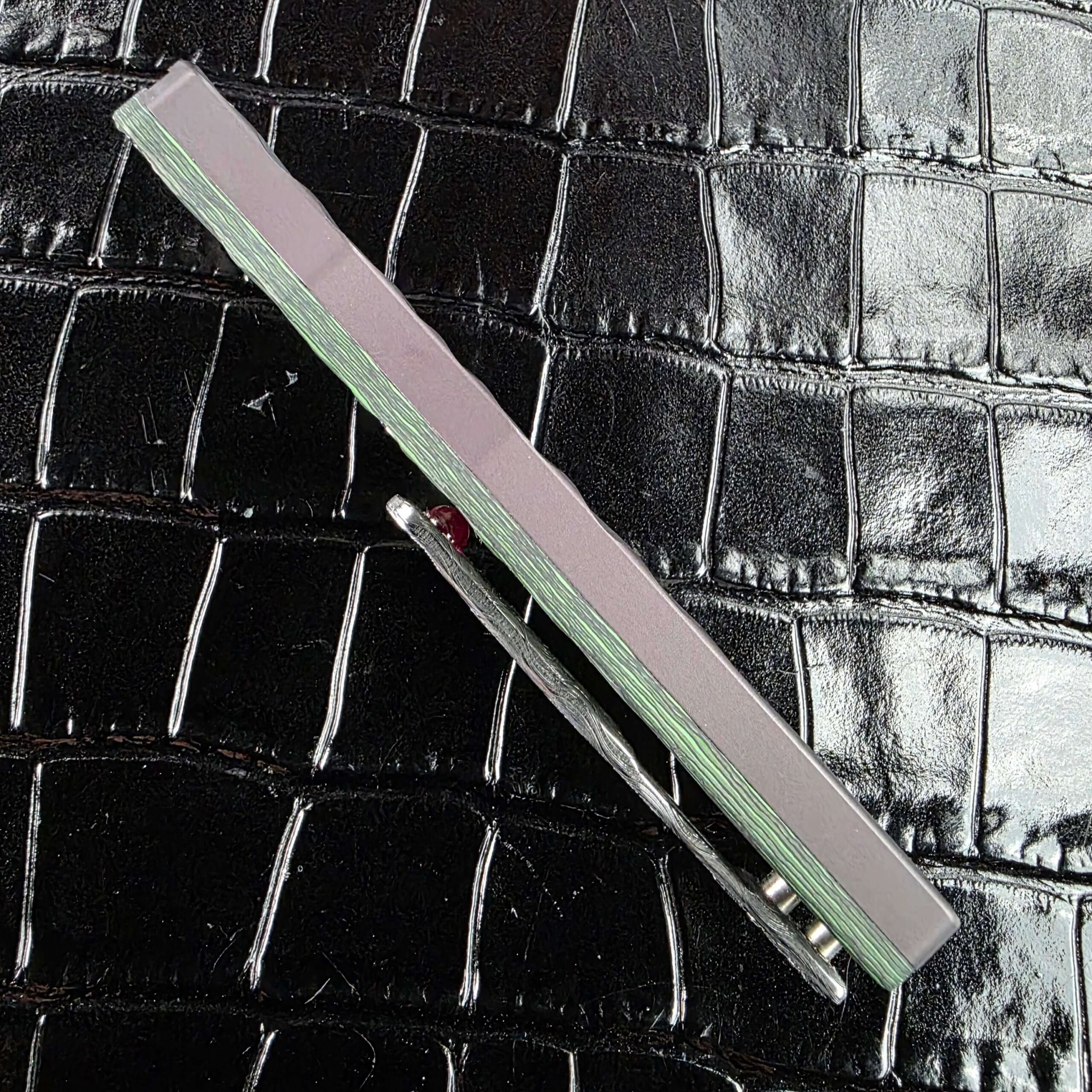Spine view of the closed Brian Tighe Tighe Twist OTF showing the slide rail and pocket clip together