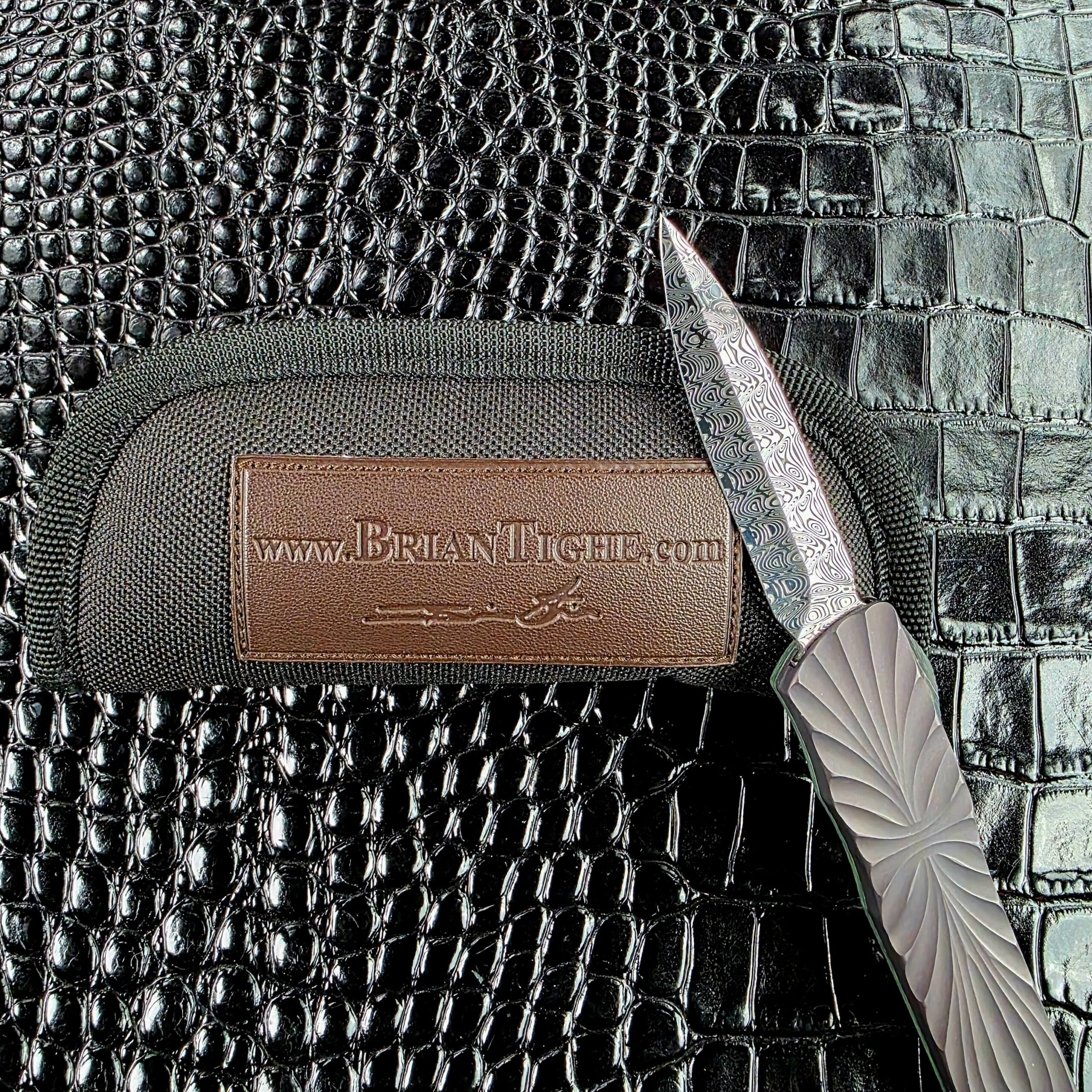 Brian Tighe Tighe Twist OTF deployed on the show side, Damasteel dagger blade and fluted titanium handle